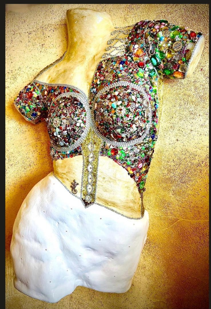 Gemstone and crystal corset bust against golden wall