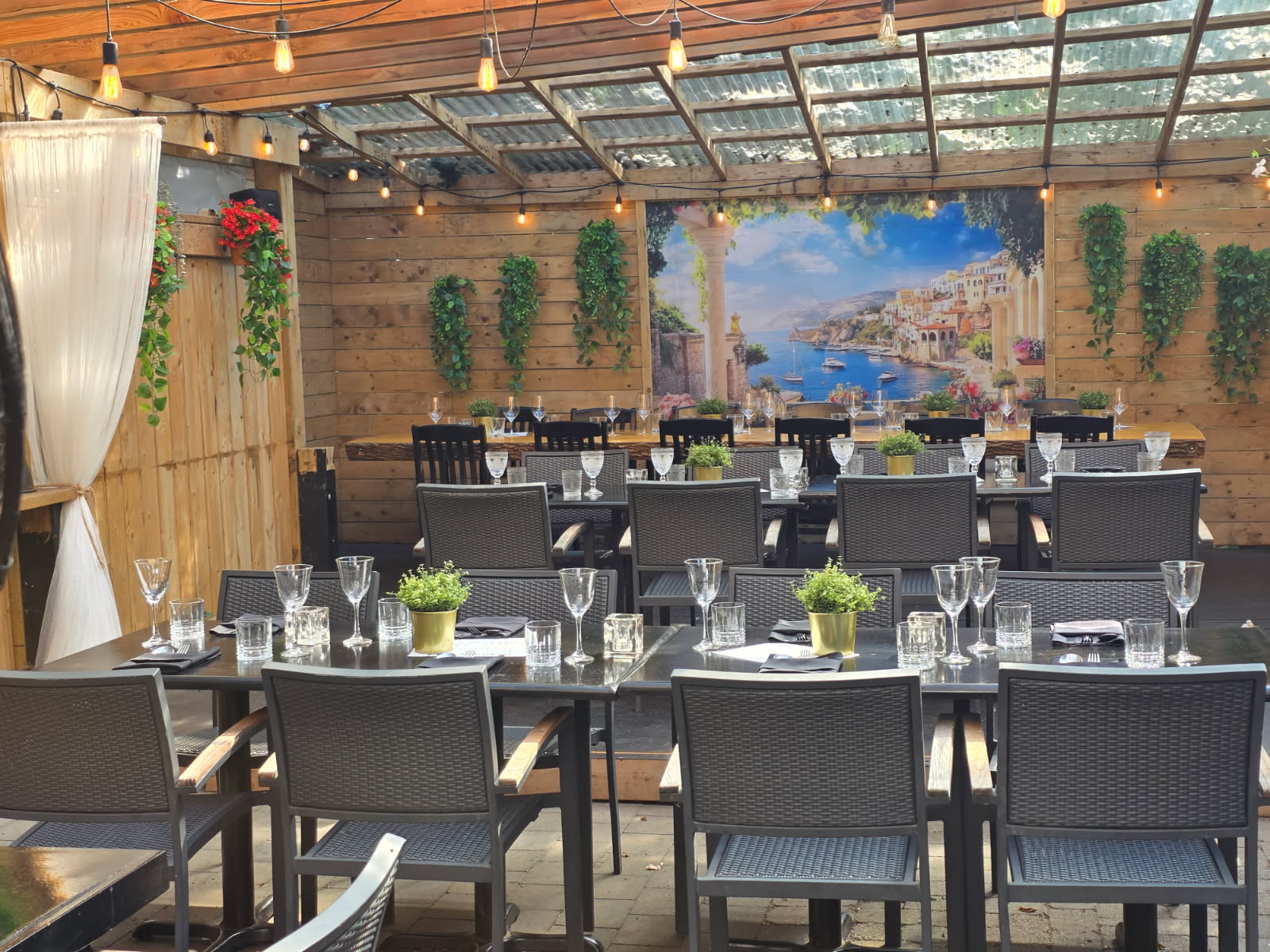 Olio patio set for private dining with Mediterranean mural and string lights