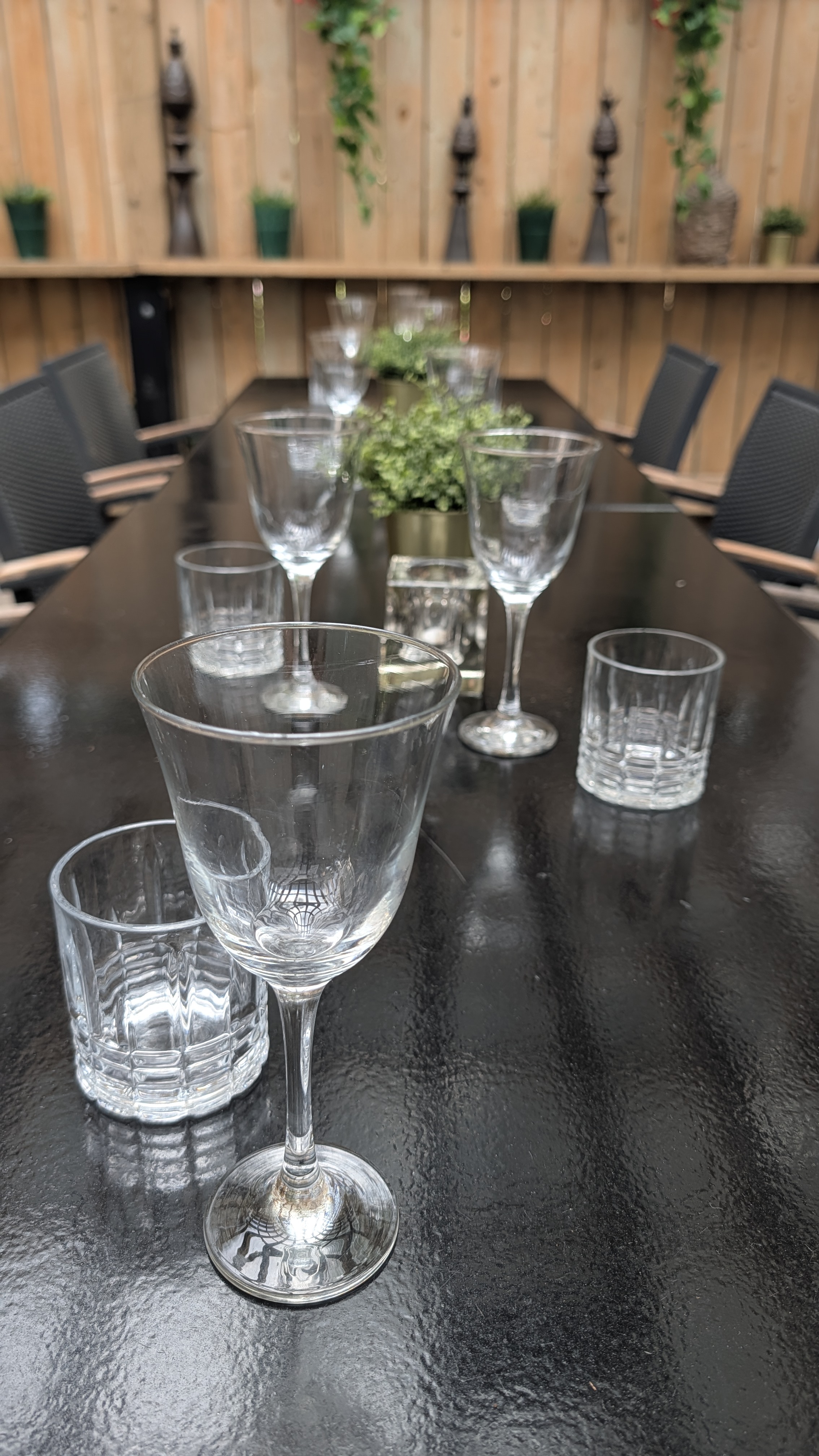 Crystal wine glass in the foreground with Olio's patio set for an intimate private event