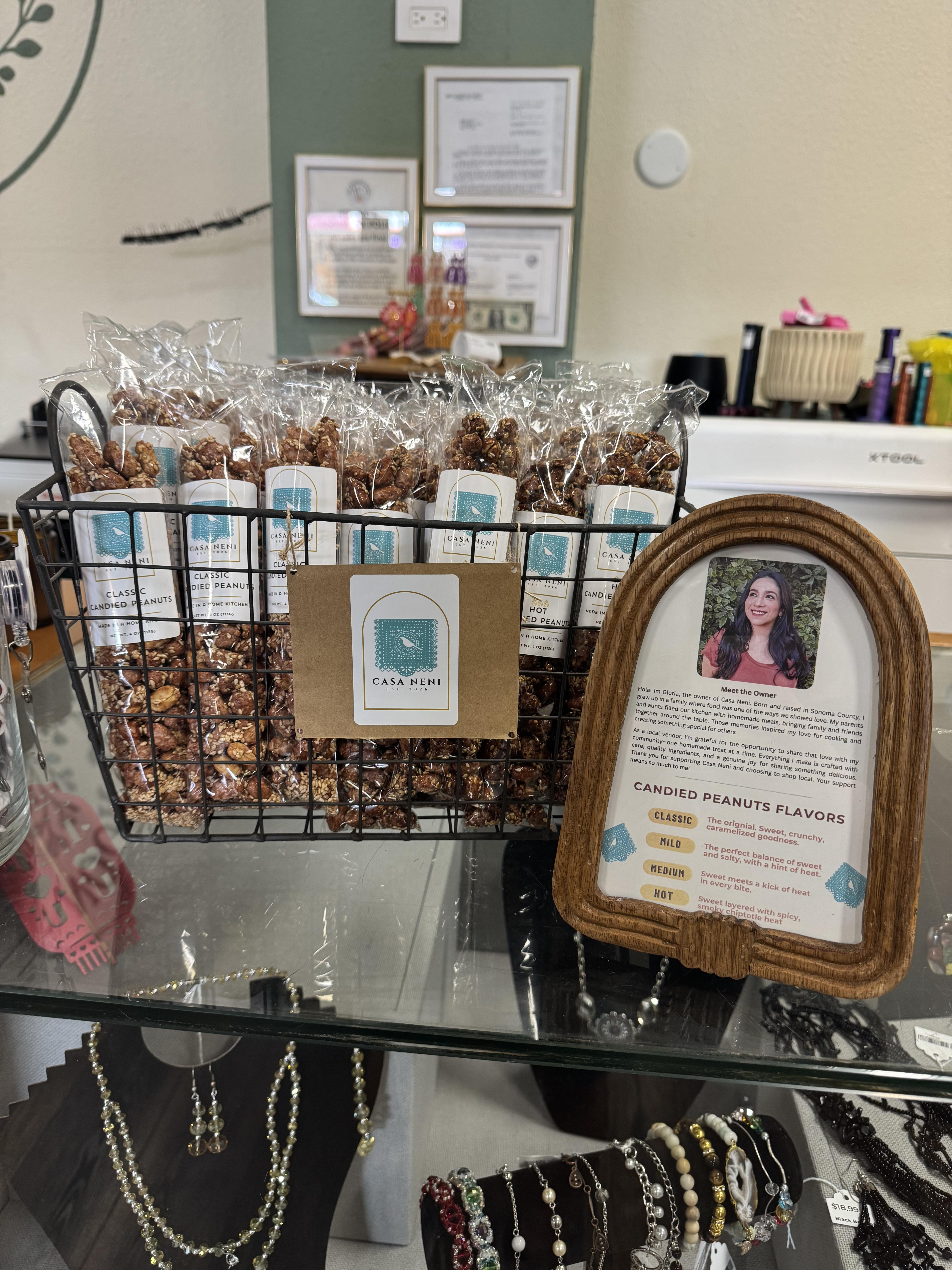 Casa Neni candied peanuts display with framed bio card