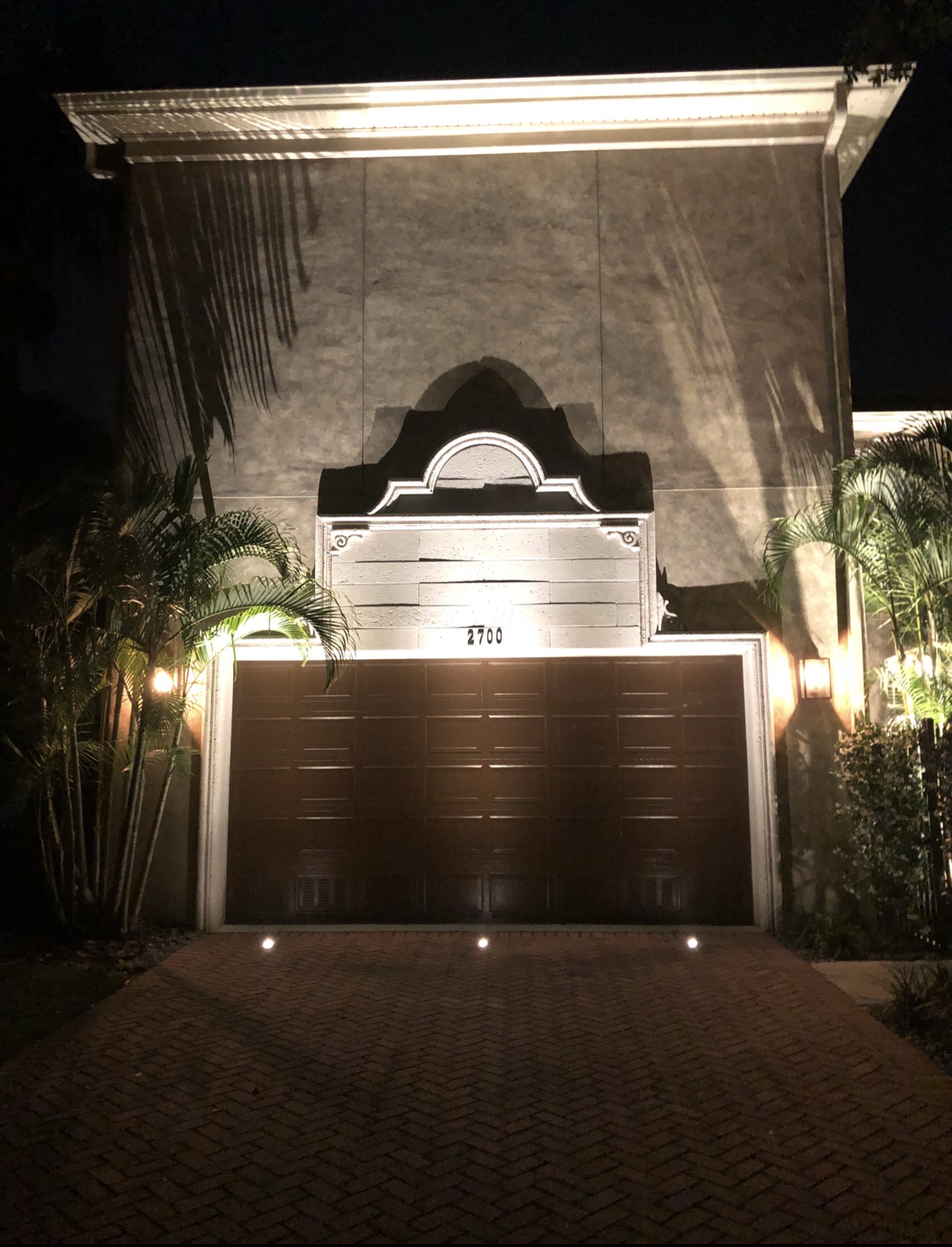 Garage facade uplighting with architectural detail lighting and palm trees — Tampa Bay luxury estate LED Artistry