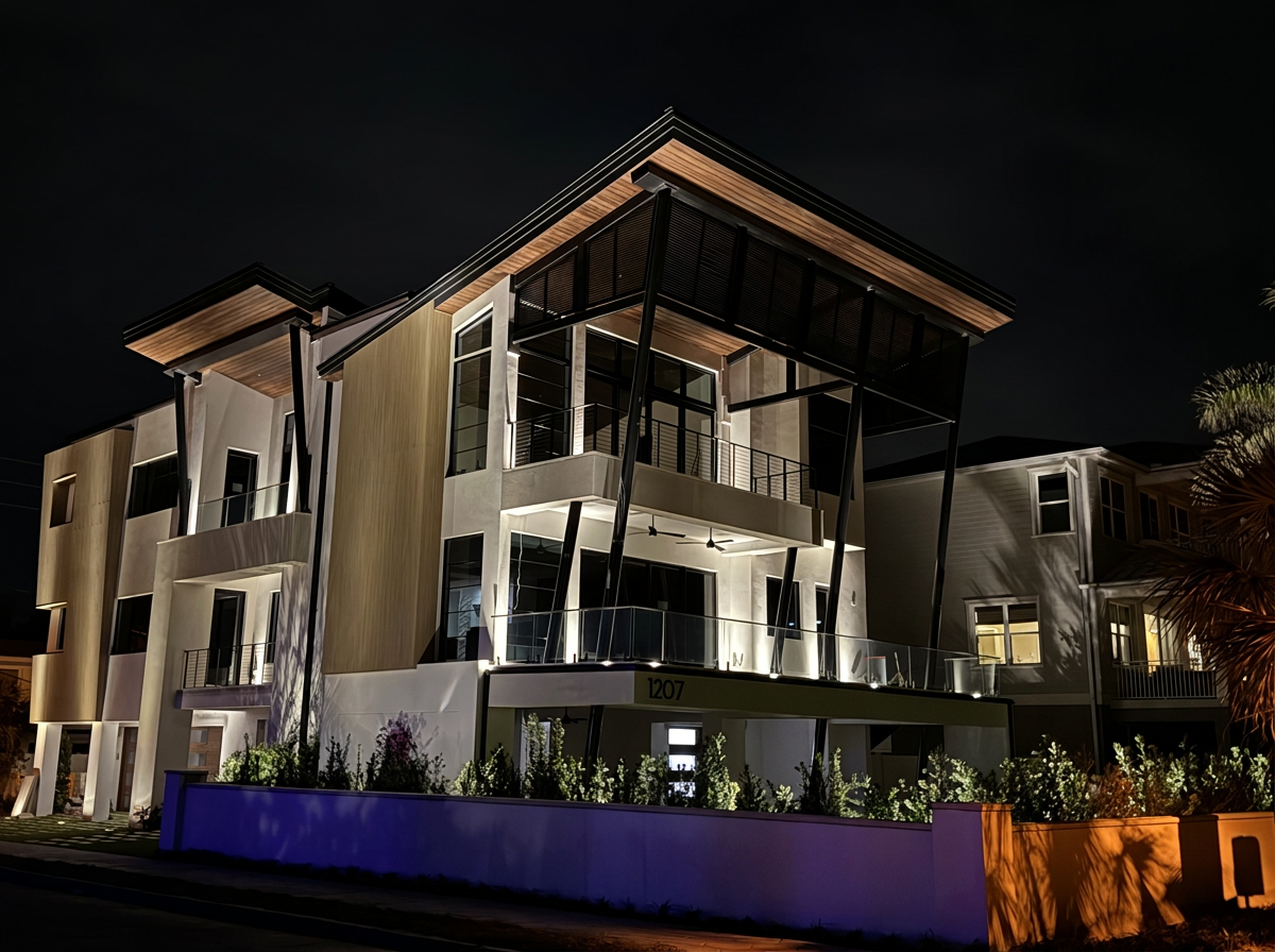 Mediterranean luxury estate at dusk with warm LED uplighting on arches and columns