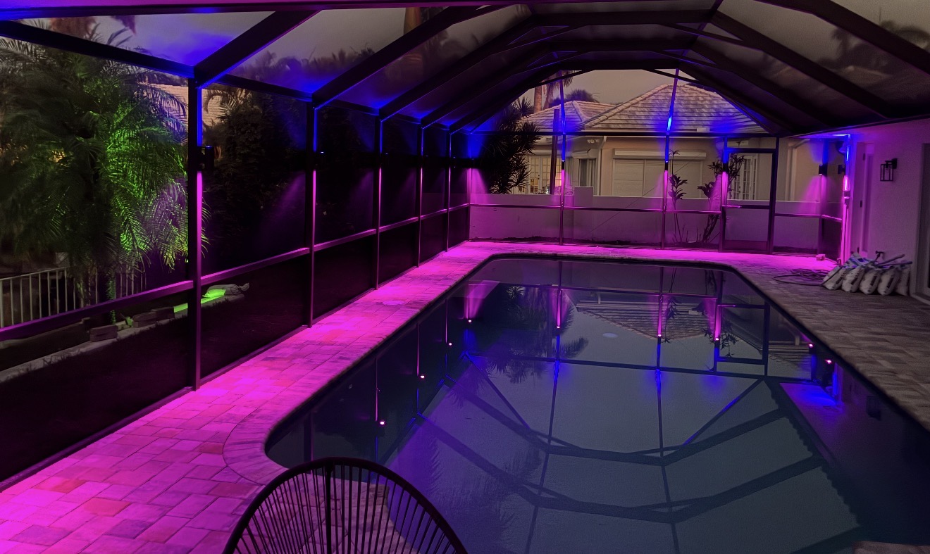 Pool cage with pink and blue RGBW LED color lighting at night, stunning reflection Tampa Bay