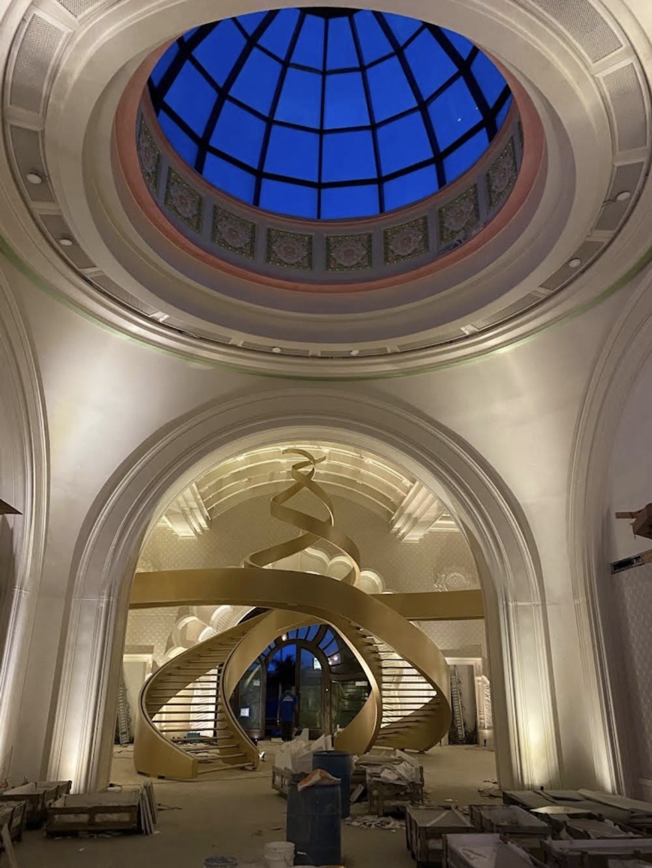 Surya Estates interior grand foyer — glass dome skylight, double-helix golden staircase, and LED uplighting by LED Artistry