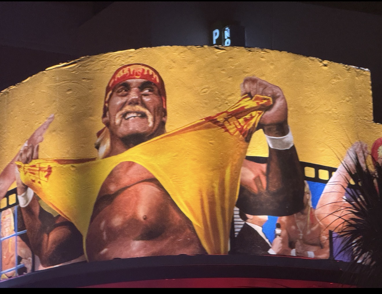 Hulk Hogan iconic mural illuminated at night on Hogan's Hangout Clearwater Beach — yellow gold lighting by LED Artistry