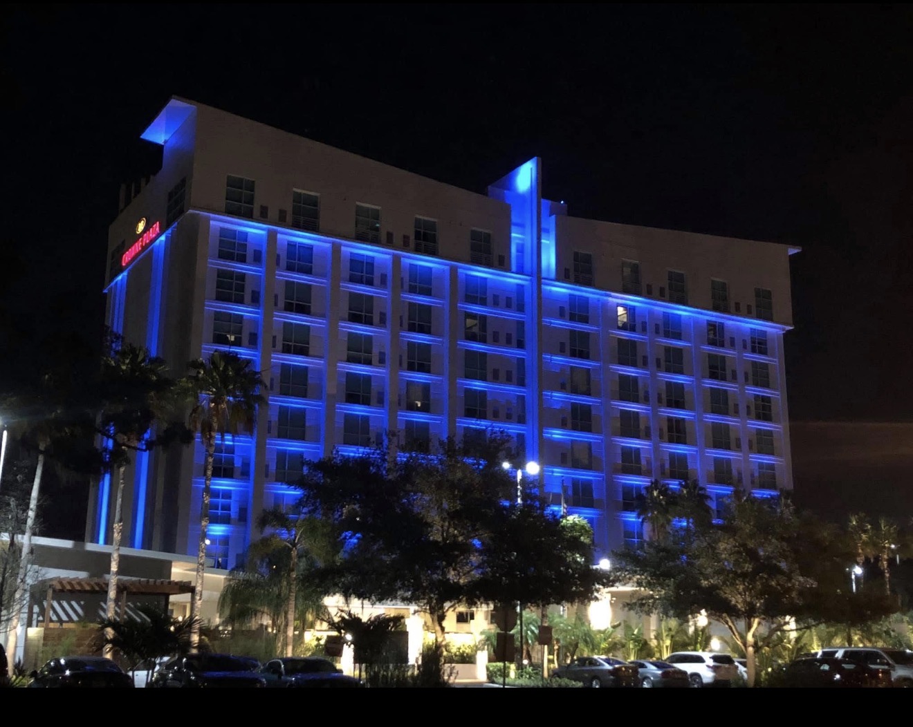 Hotel Alba Tampa wide exterior view — full building blue RGBW facade lighting, warm white entrance and landscape uplighting by LED Artistry