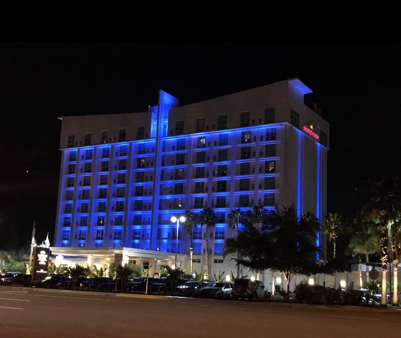 Hotel Alba Tampa formerly Crowne Plaza full exterior at night — RGBW blue facade wash across all 11 stories, porte-cochère, and landscape uplighting by LED Artistry