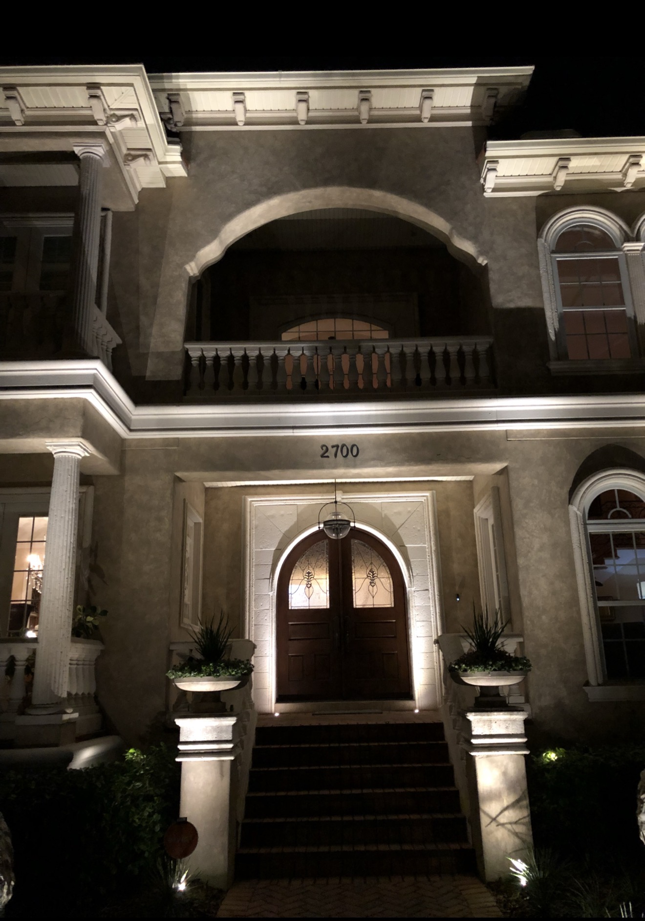 Grand entrance archway with uplighted columns and balustrades — luxury Tampa Bay estate by LED Artistry