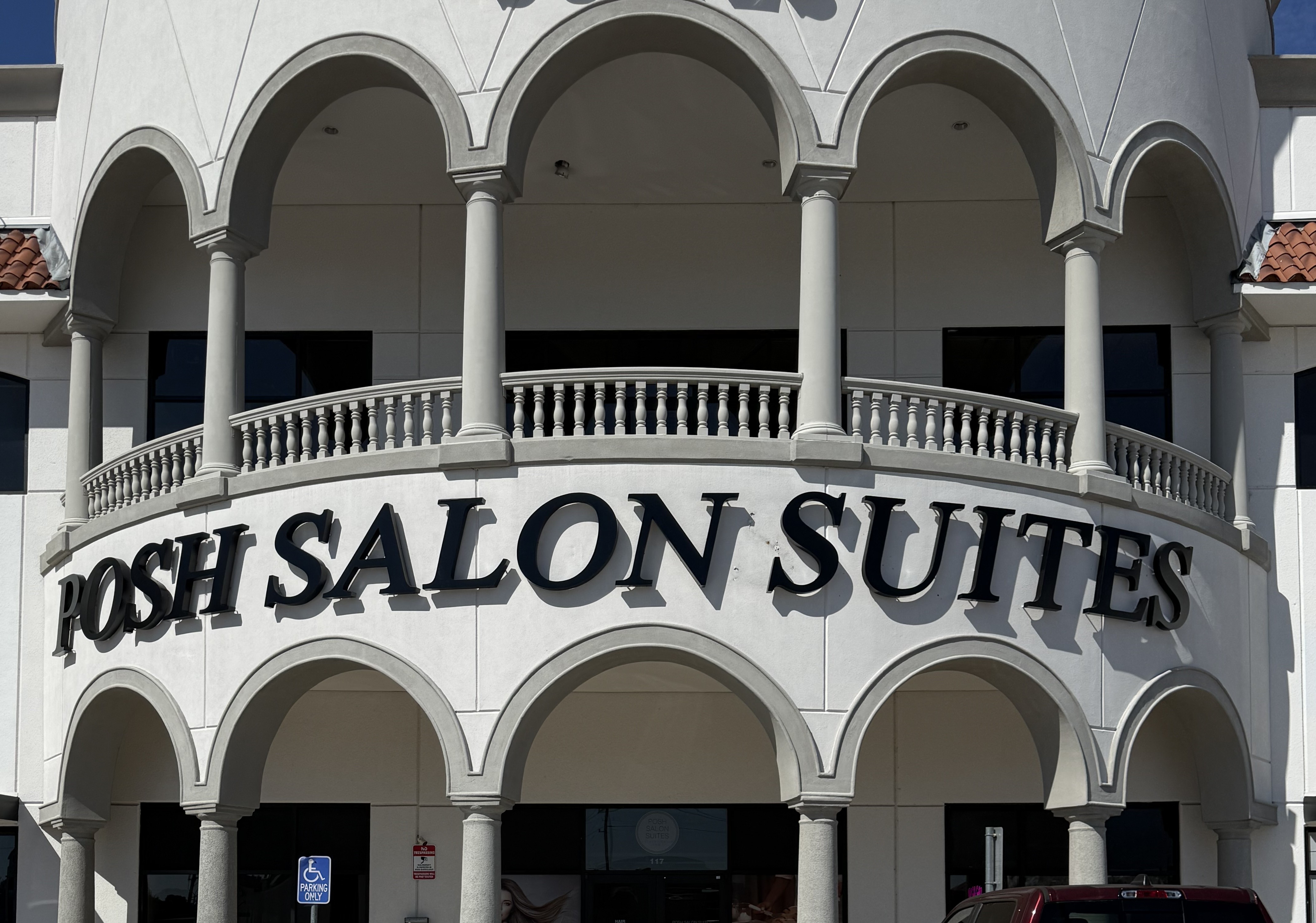 Posh Salon Suites building exterior with arched columns and signage in Spring, Texas near The Woodlands