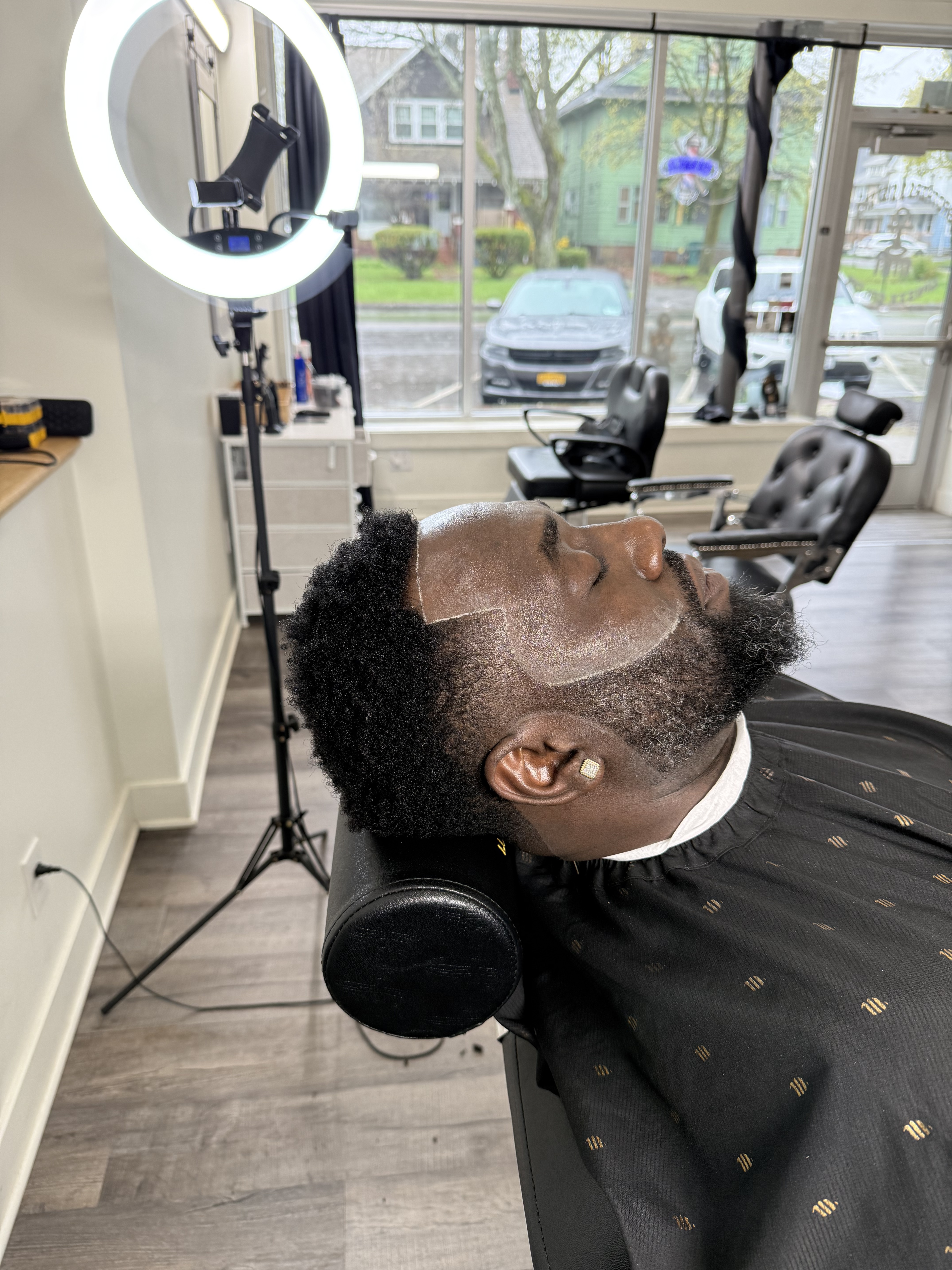 Client in the barber chair with razor-sharp lineup at Pure Masters Lounge