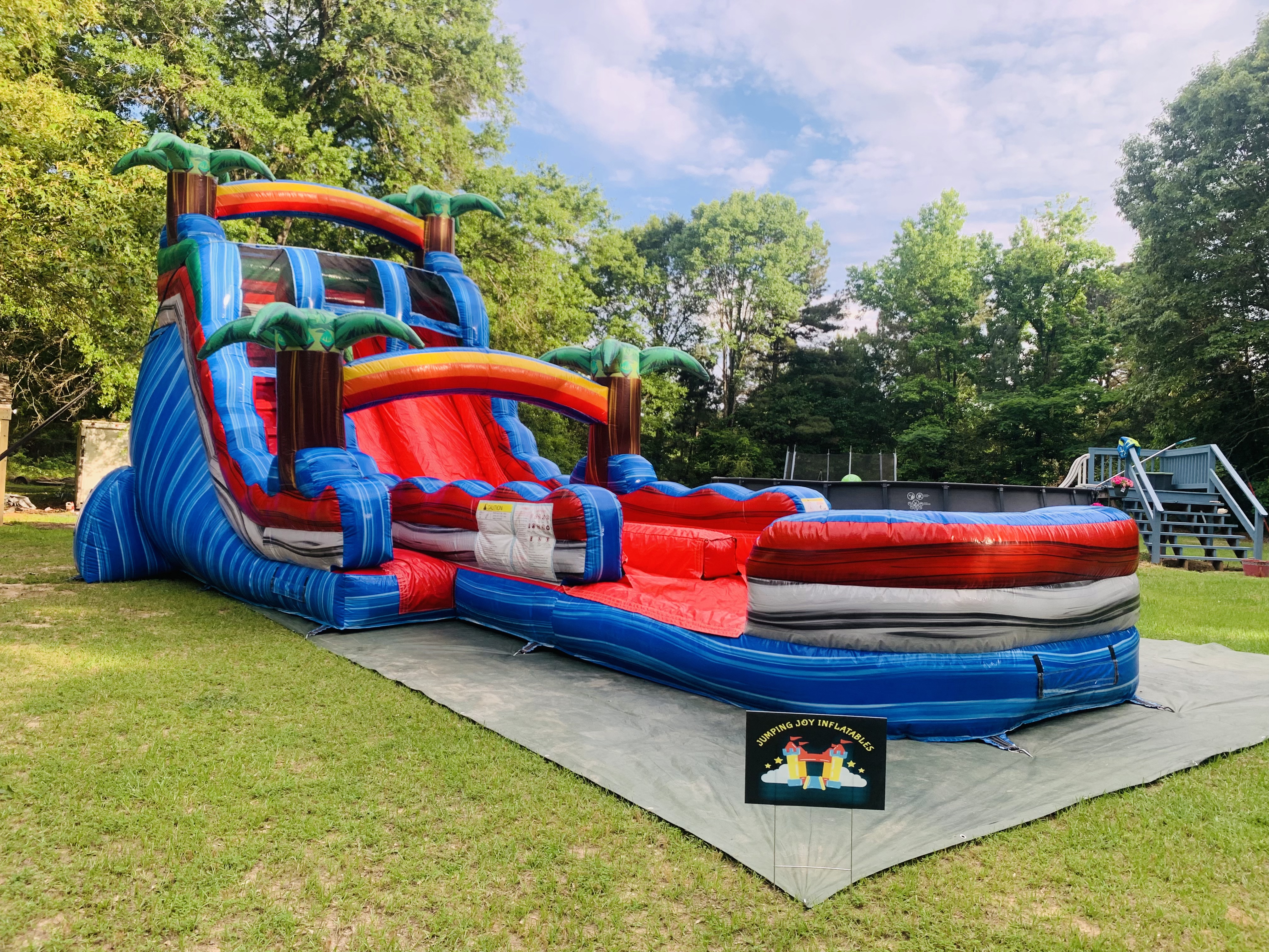 Baja Splash dual lane water slide with palm trees and splash pool — Jumping Joy Inflatables