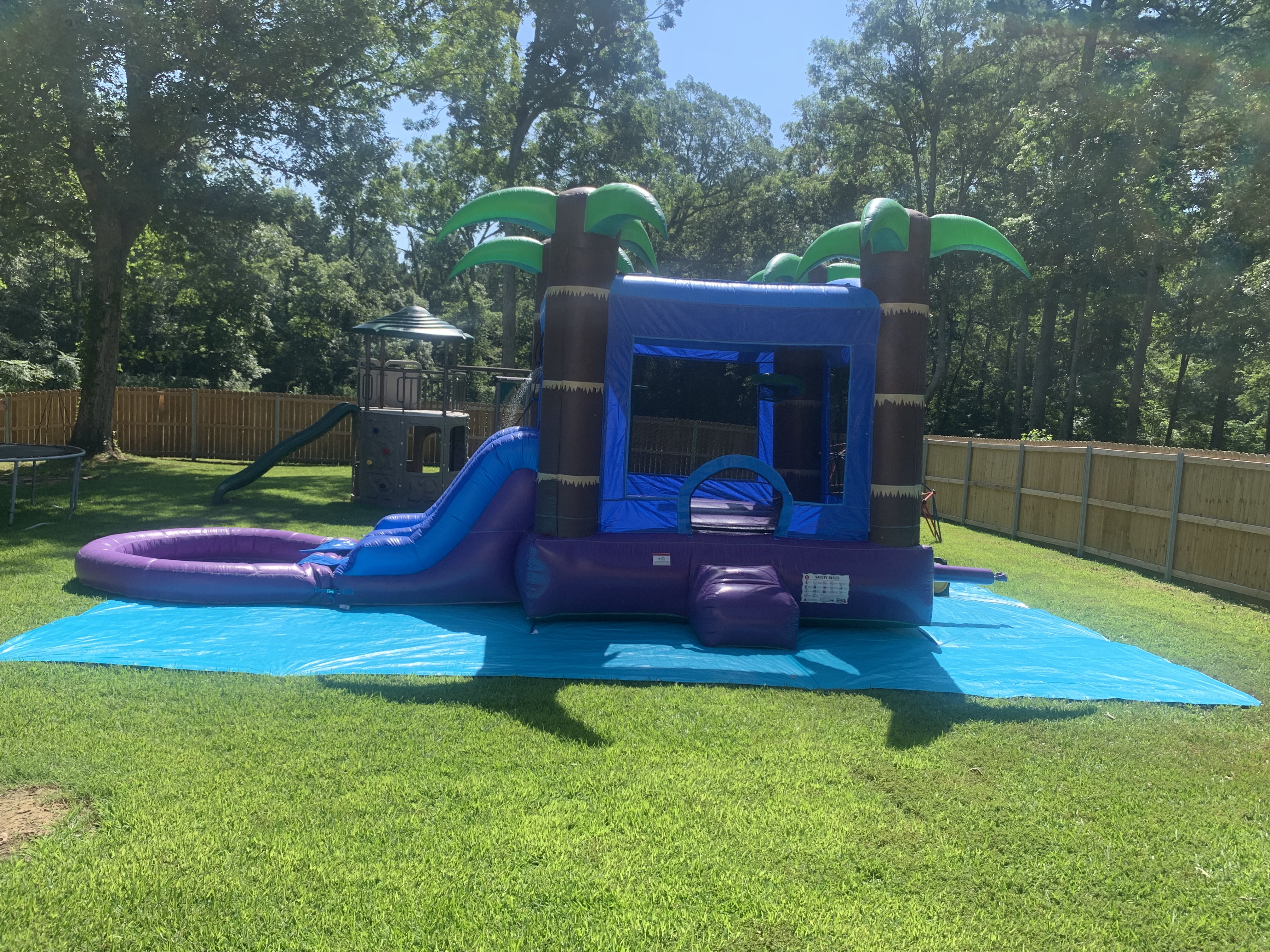 Tropical Storm combo unit with water slide and splash pool in backyard