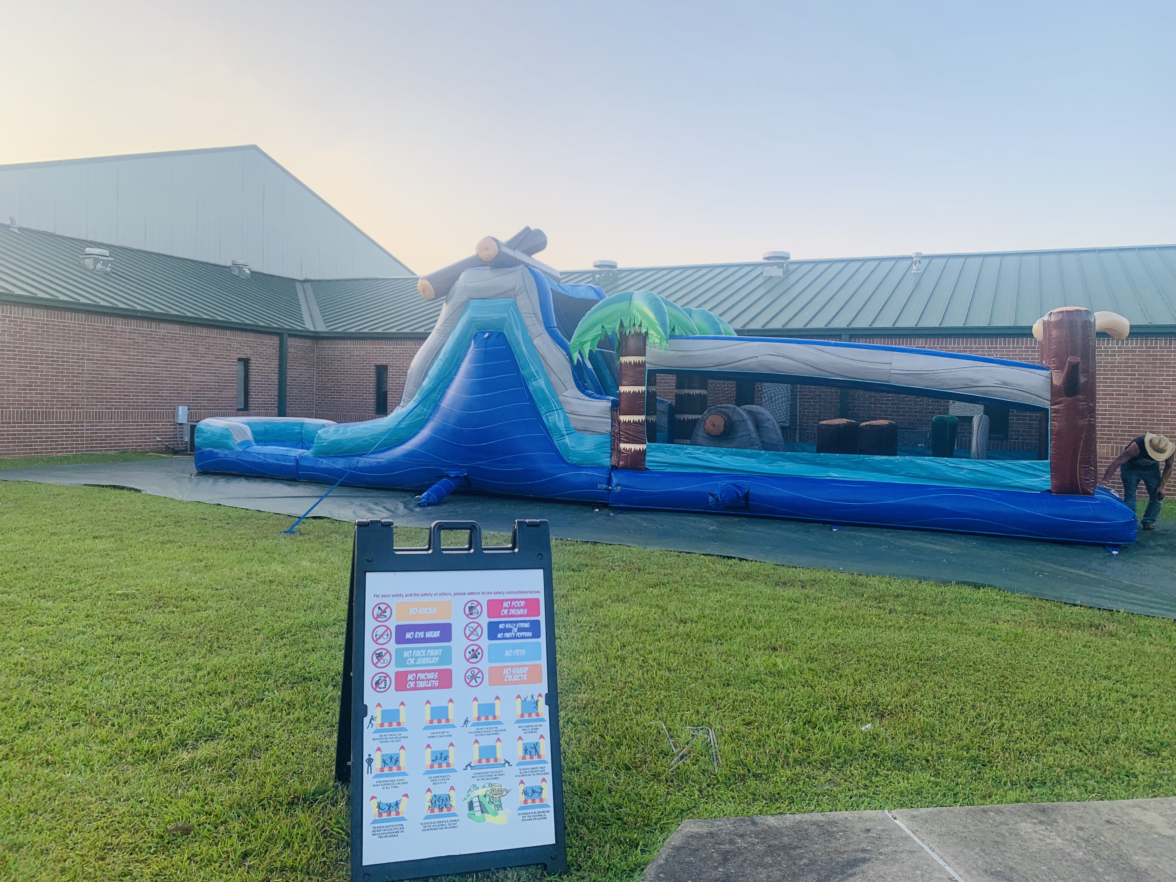 Log Jam Lagoon obstacle course set up outside a school or church venue with safety sign in foreground