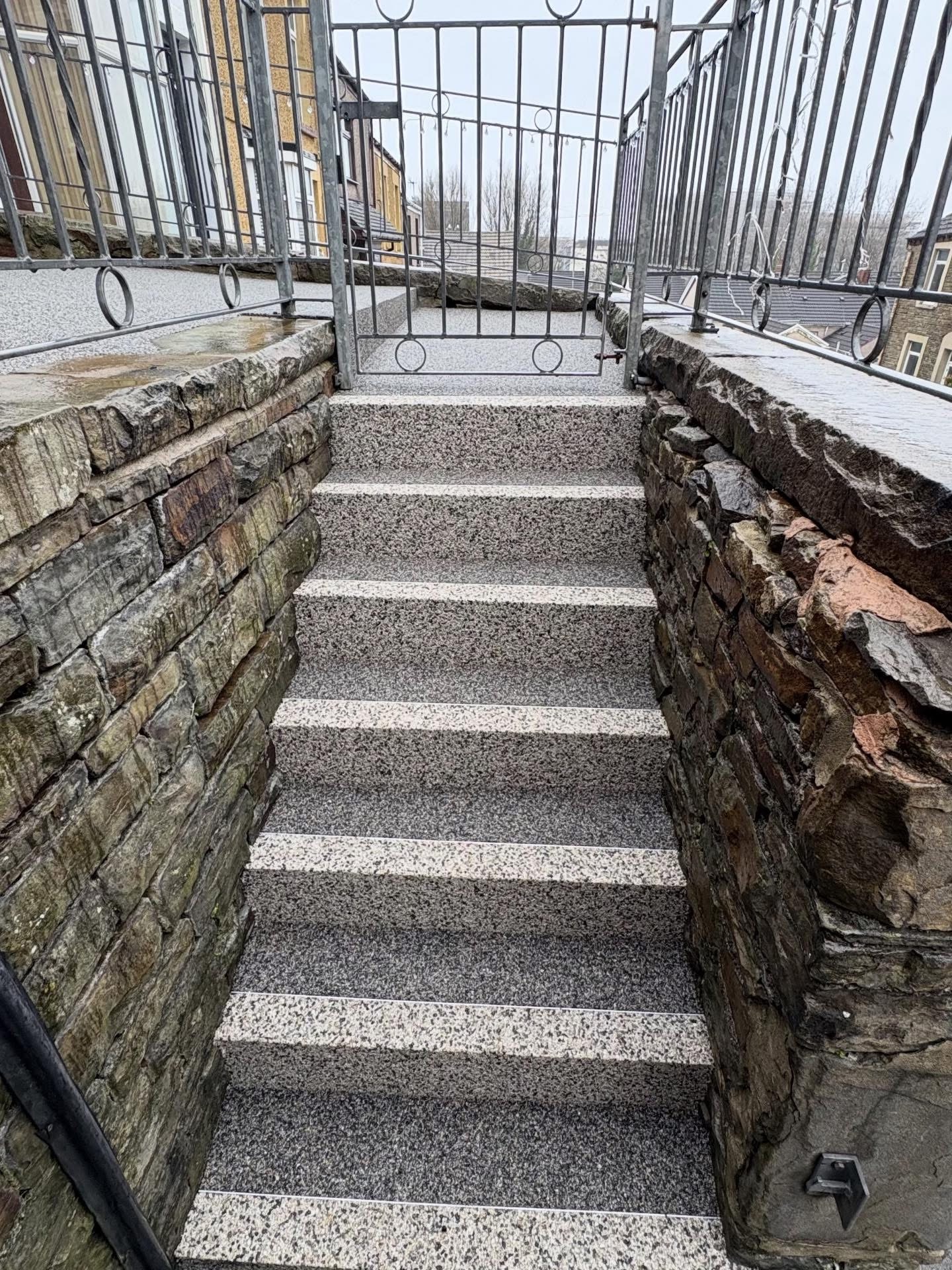 Resin bound steps with anti-slip nosings between stone walls - grey aggregate