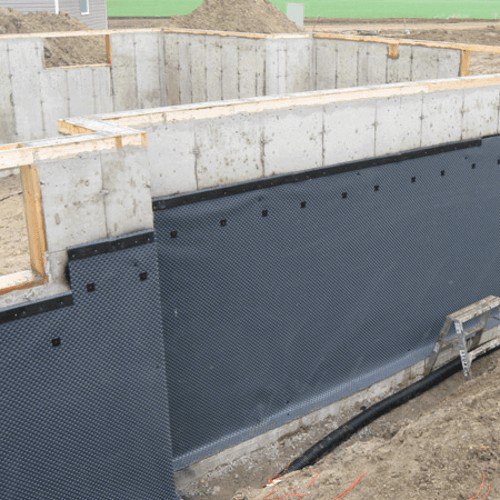 Below-grade foundation wall with drainage board installed — before backfill