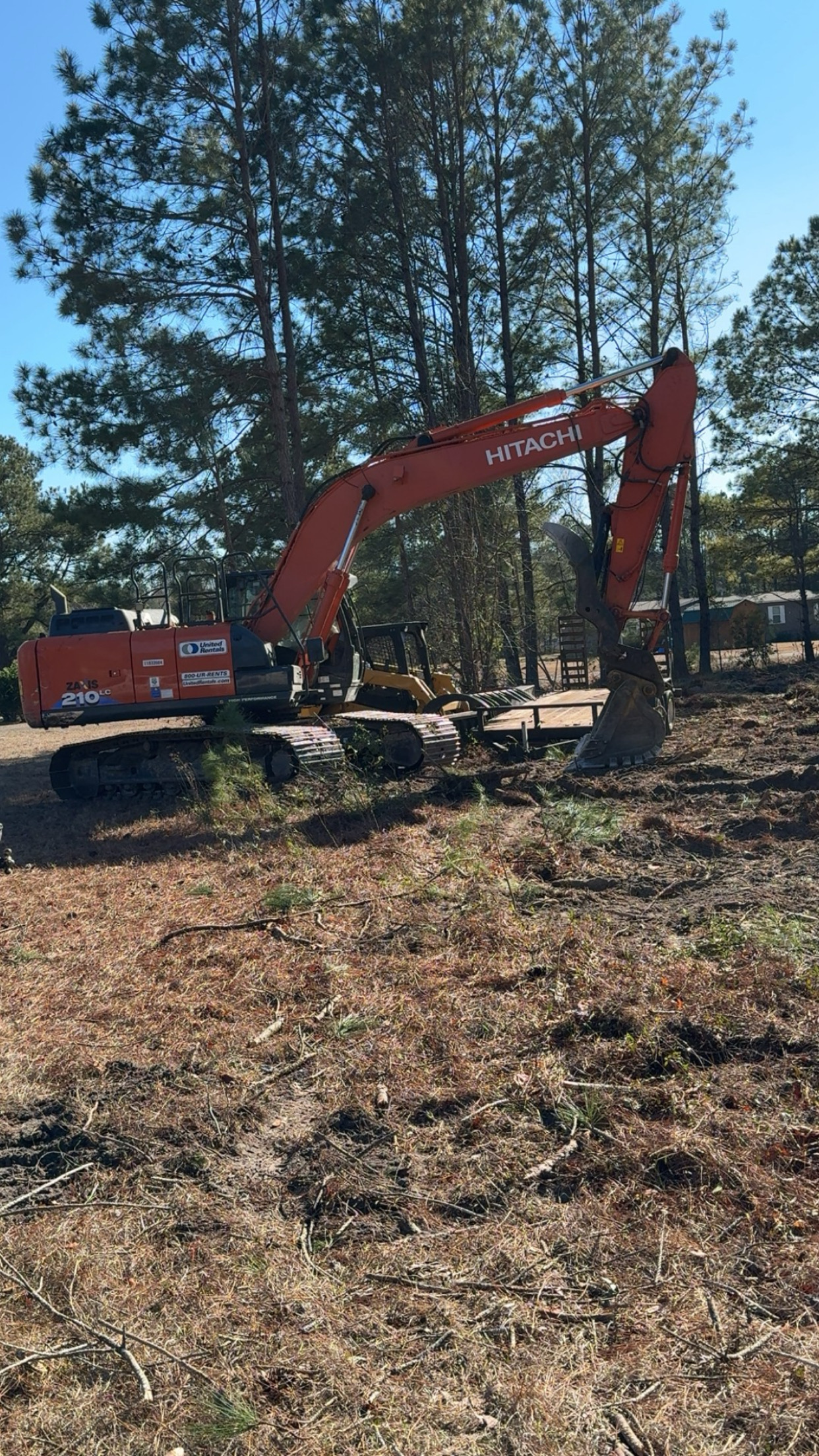 Hitachi 210LC excavator clearing trees and brush on a wooded residential lot, by Stukes Construction