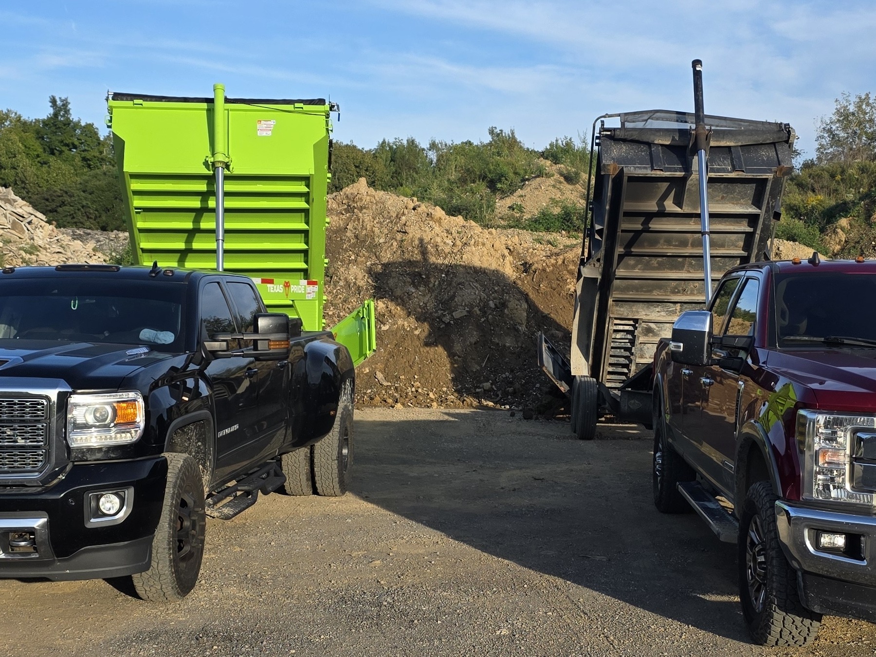 JT Ground Pounders dump trailers tipped up after dropping loads of soil and stone
