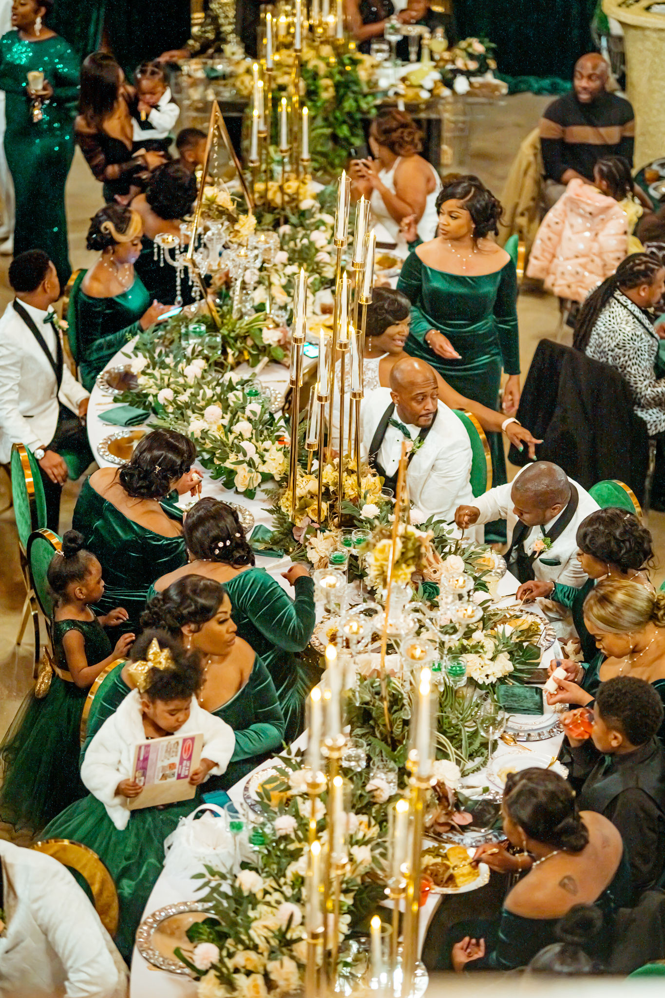Luxury emerald and gold wedding dinner table with guests