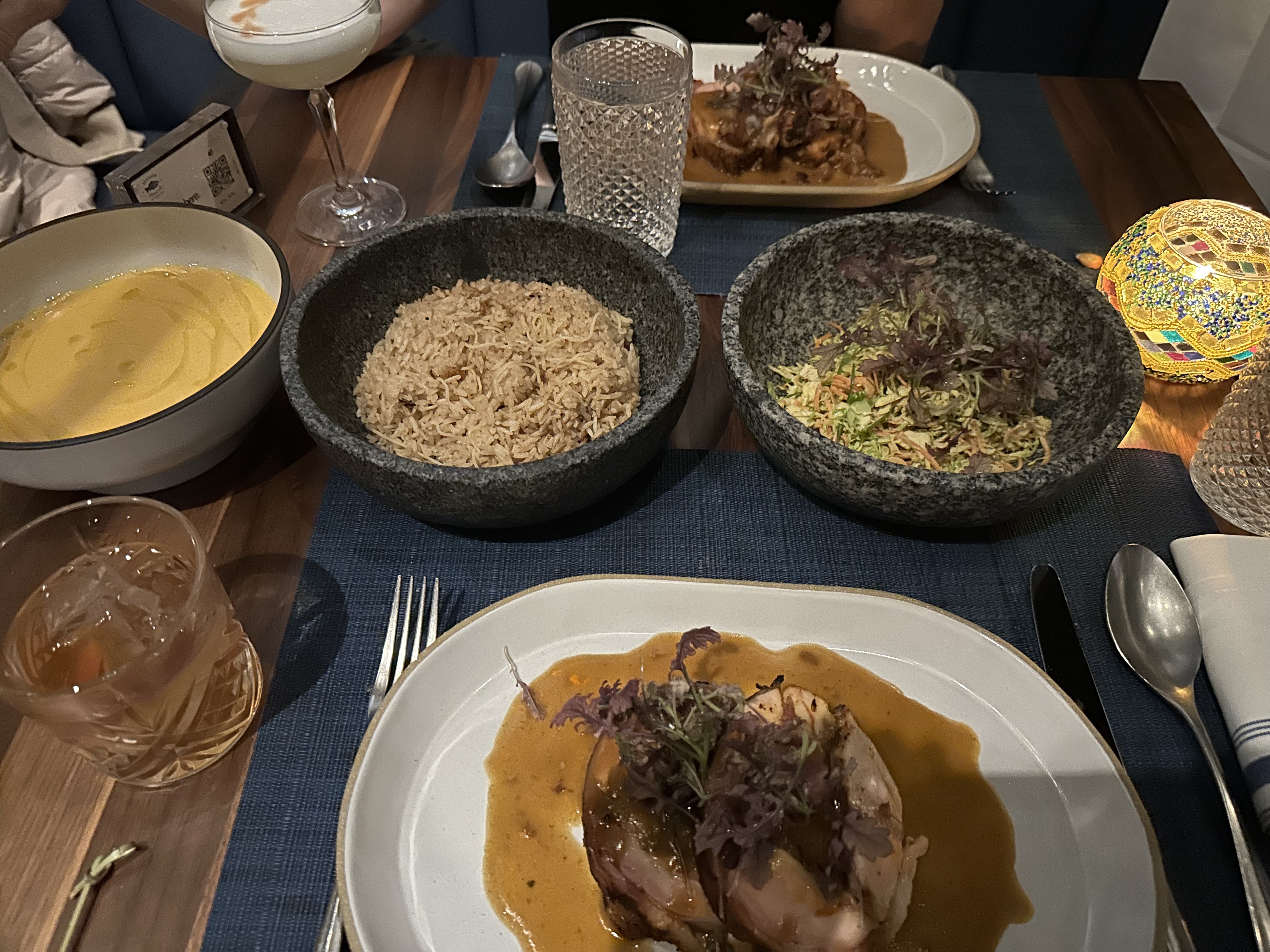 Mission Ceviche dinner — chicken in golden sauce, rice and salad in stone molcajete bowls, craft cocktails