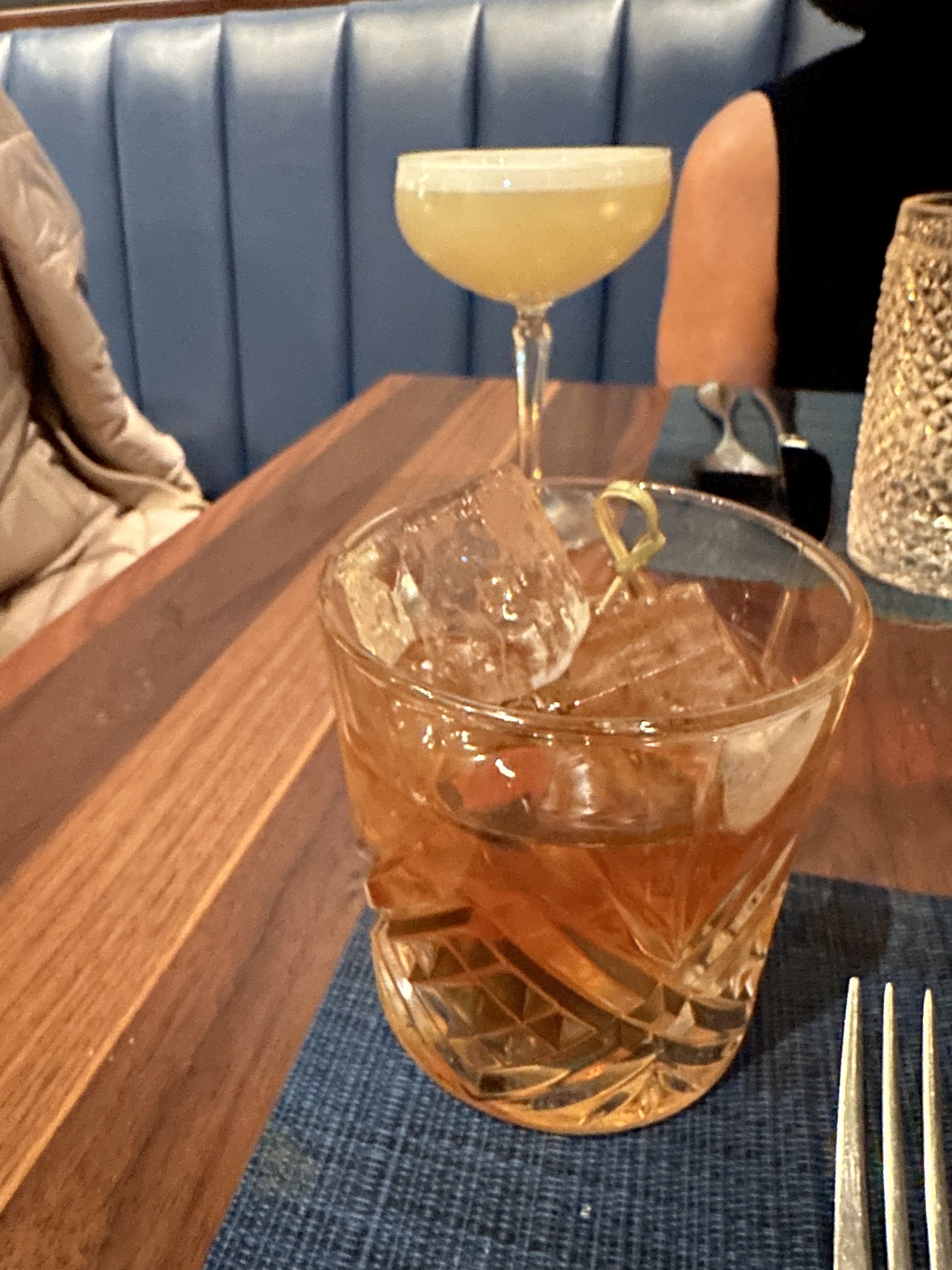 Mission Ceviche craft cocktails — old fashioned and coupe glass on wooden table with blue leather booth