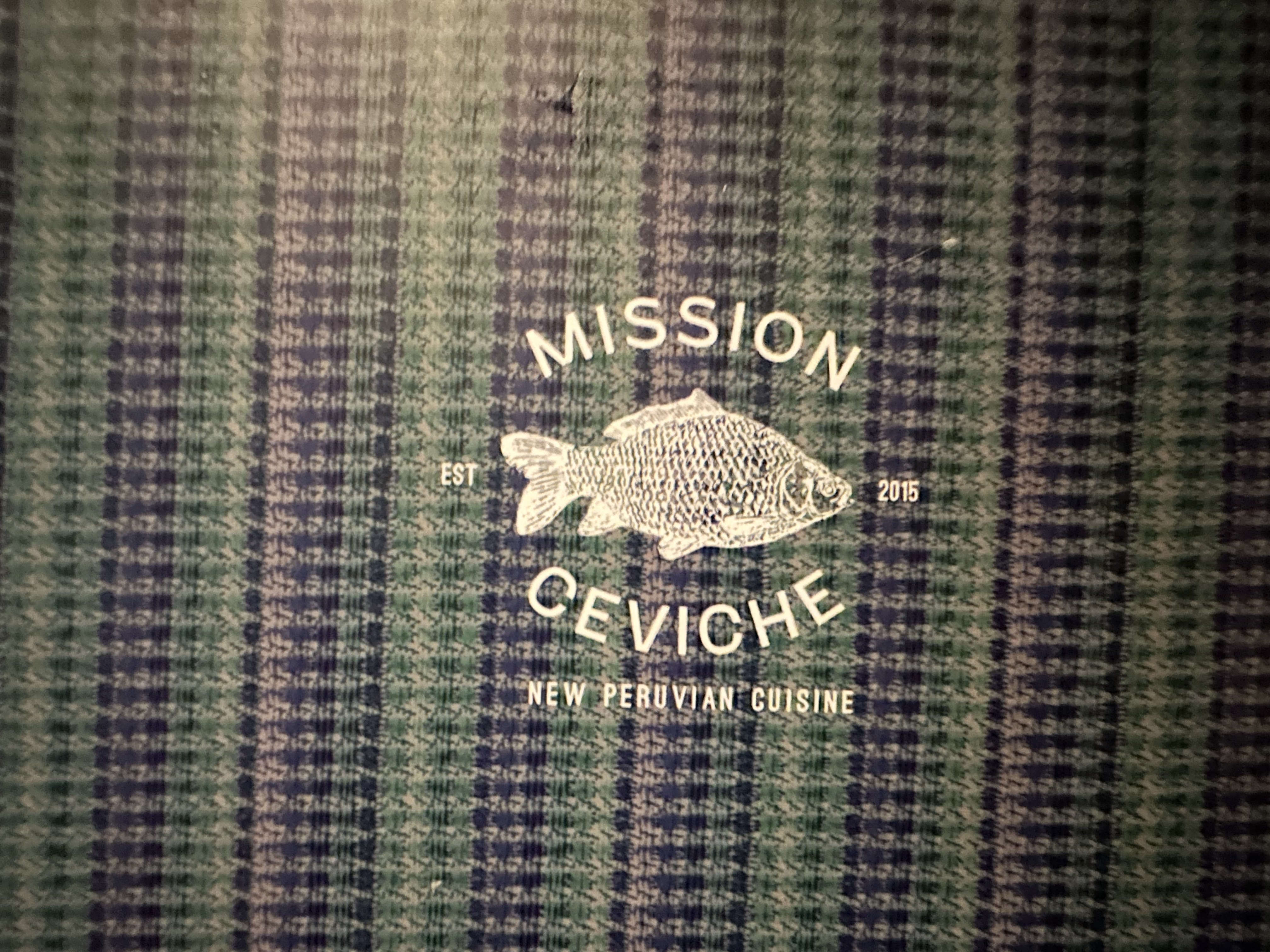 Mission Ceviche — New Peruvian Cuisine — Est. 2015 — logo on textured fabric