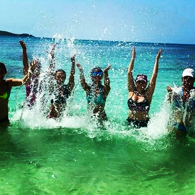 Group of friends splashing in the turquoise Caribbean ocean in Puerto Rico