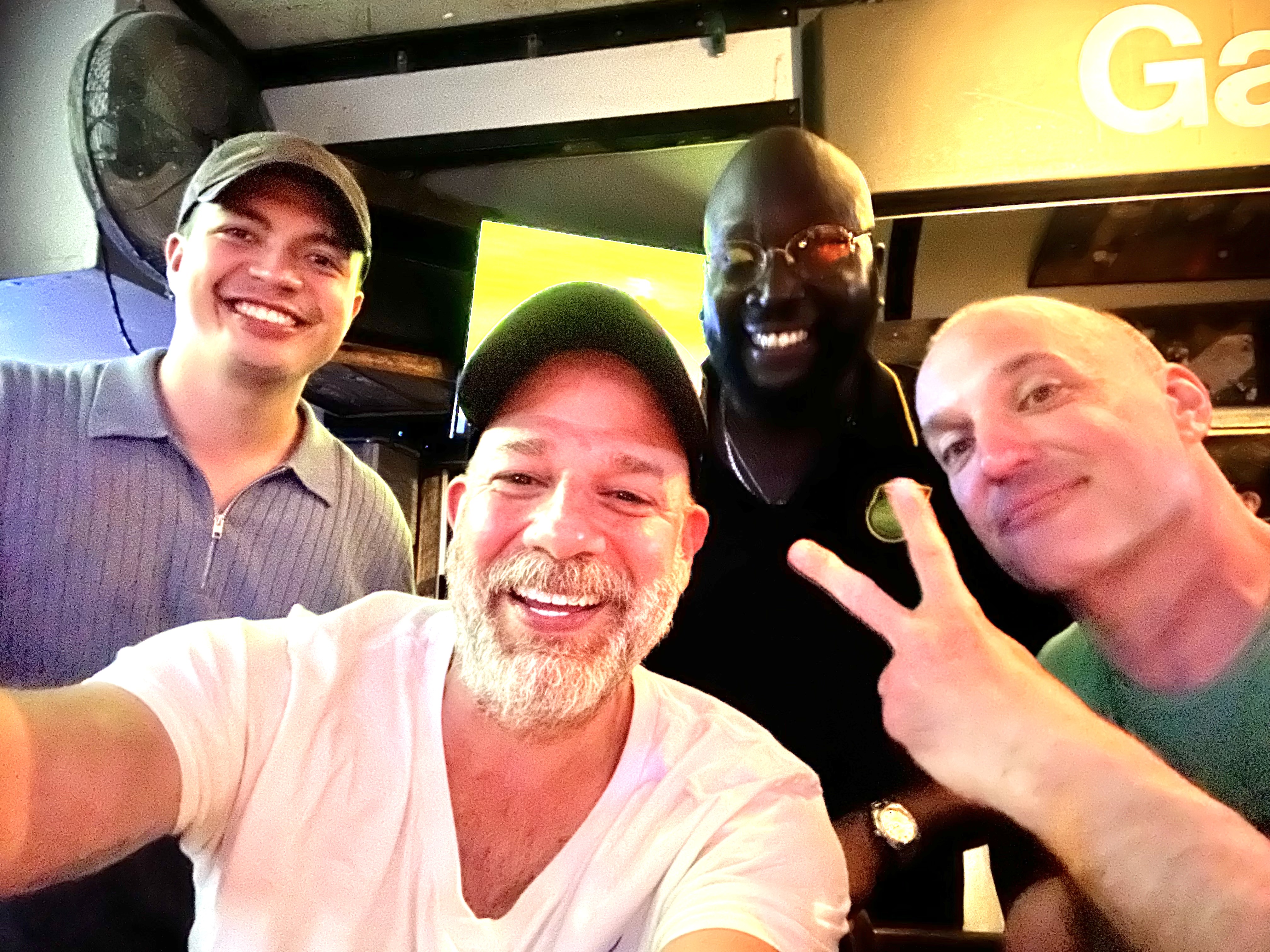 Xavier and friends group selfie at 668 The Gig Shack — four people smiling at the bar, Montauk Saturday night
