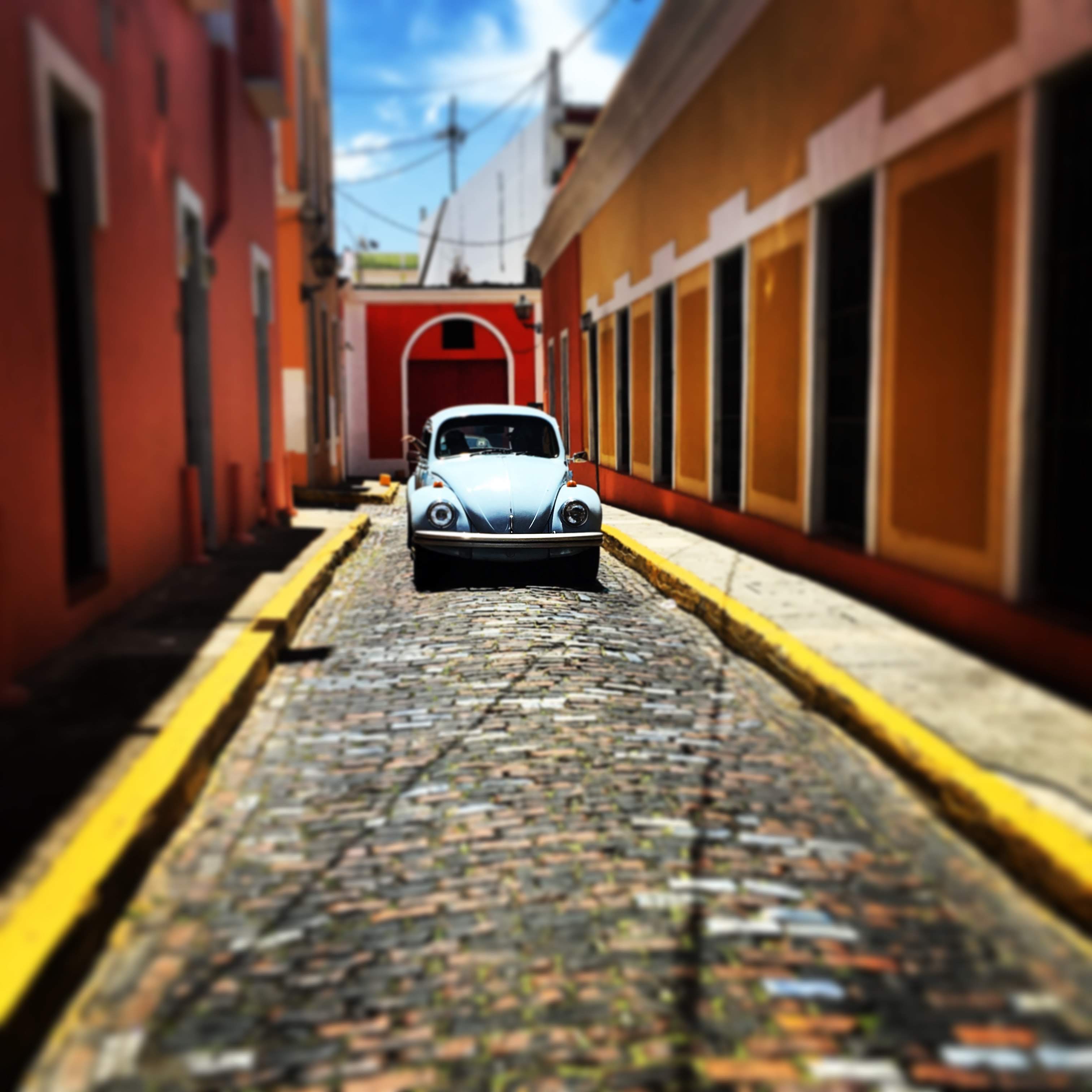 Classic VW Beetle on a cobblestone street in Old San Juan, Puerto Rico β colorful colonial buildings, yellow curbs