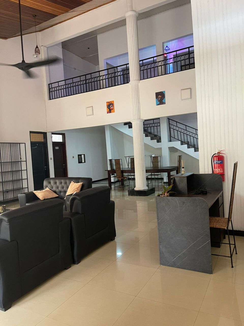 Nteasee House grand hall with double-height ceilings, art, and reception desk