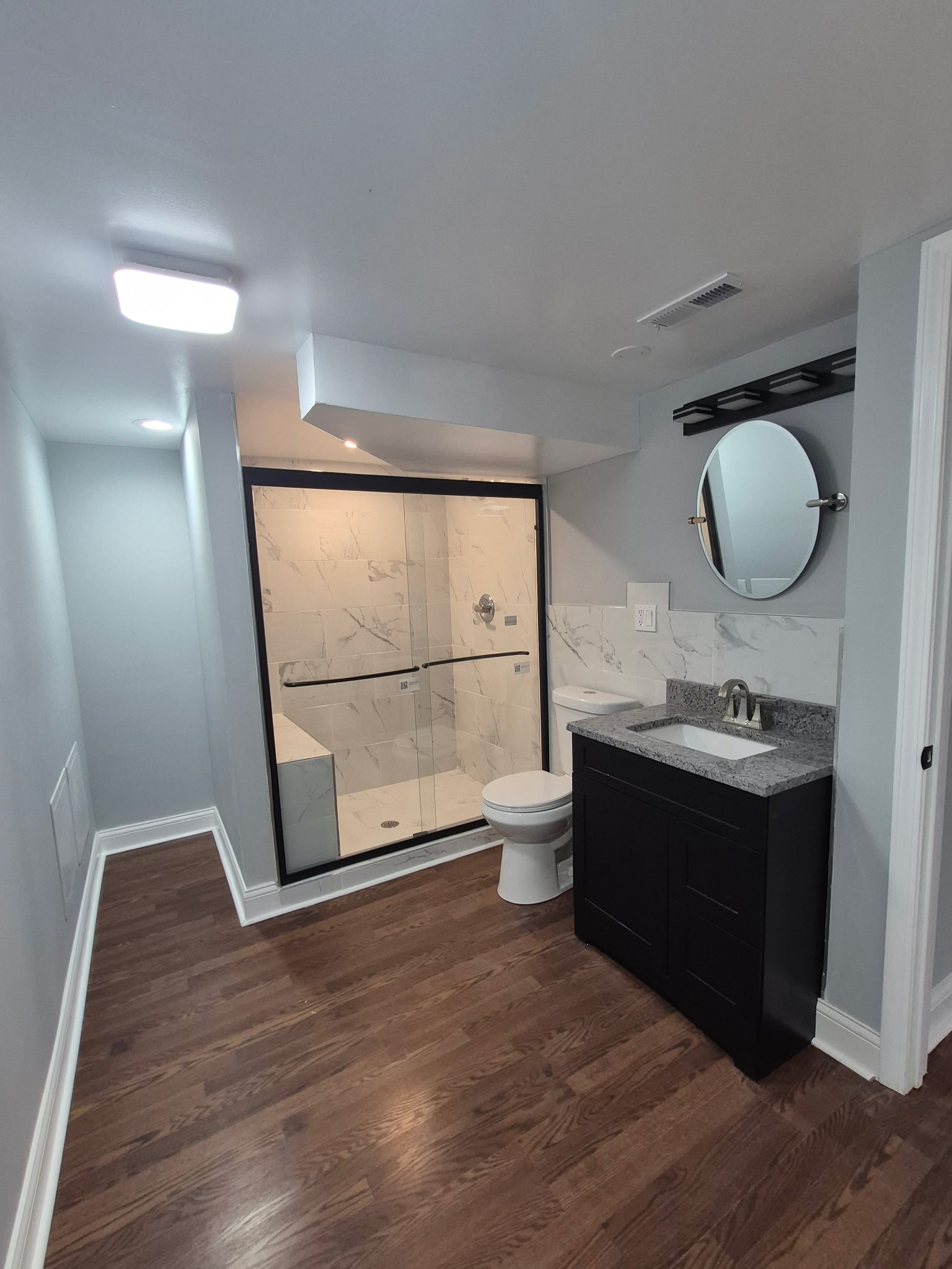 Custom bathroom with marble tile shower and granite vanity