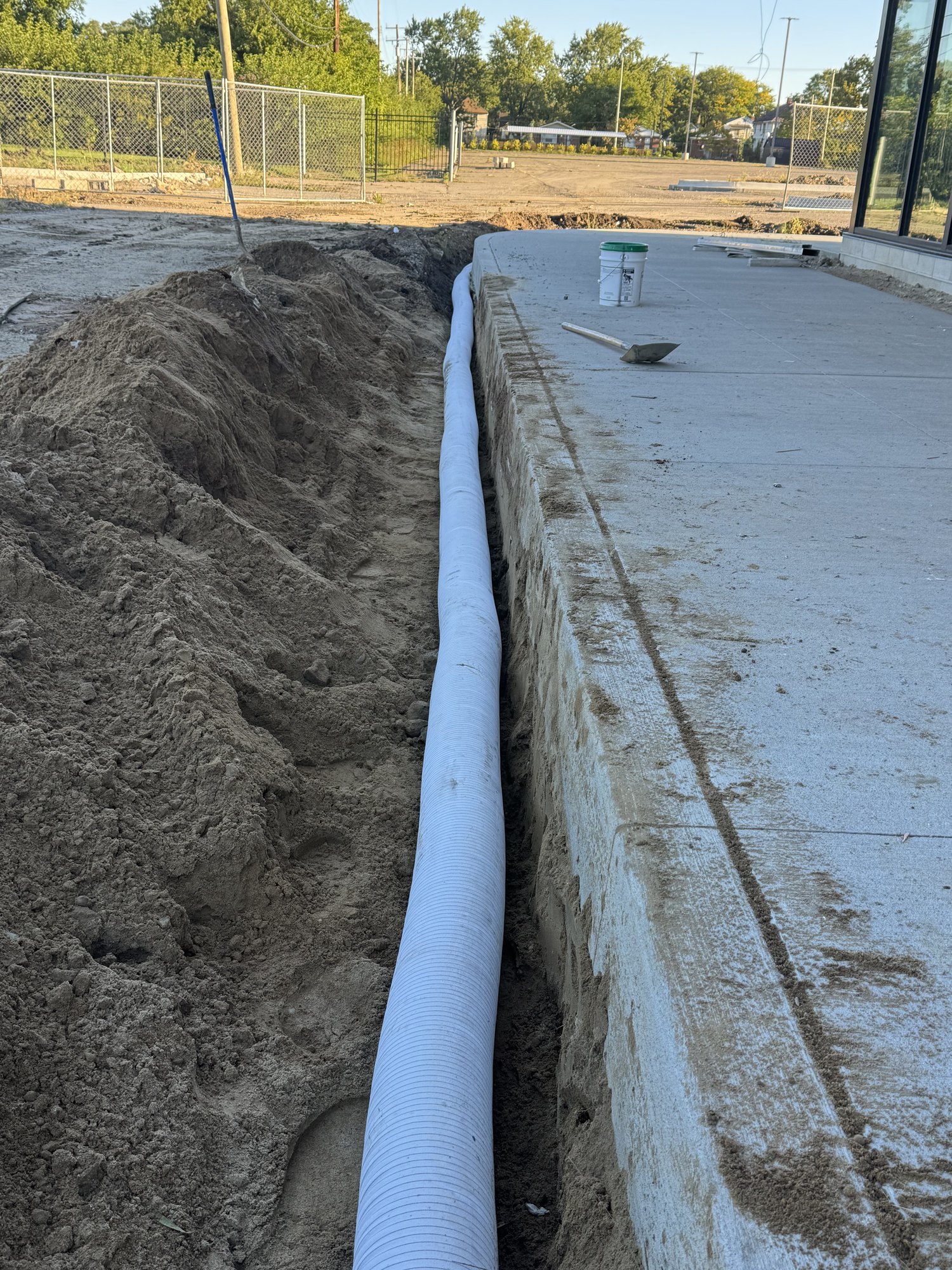 Surface Edge Drain — Sock-Wrapped HDPE Along Slab Edge