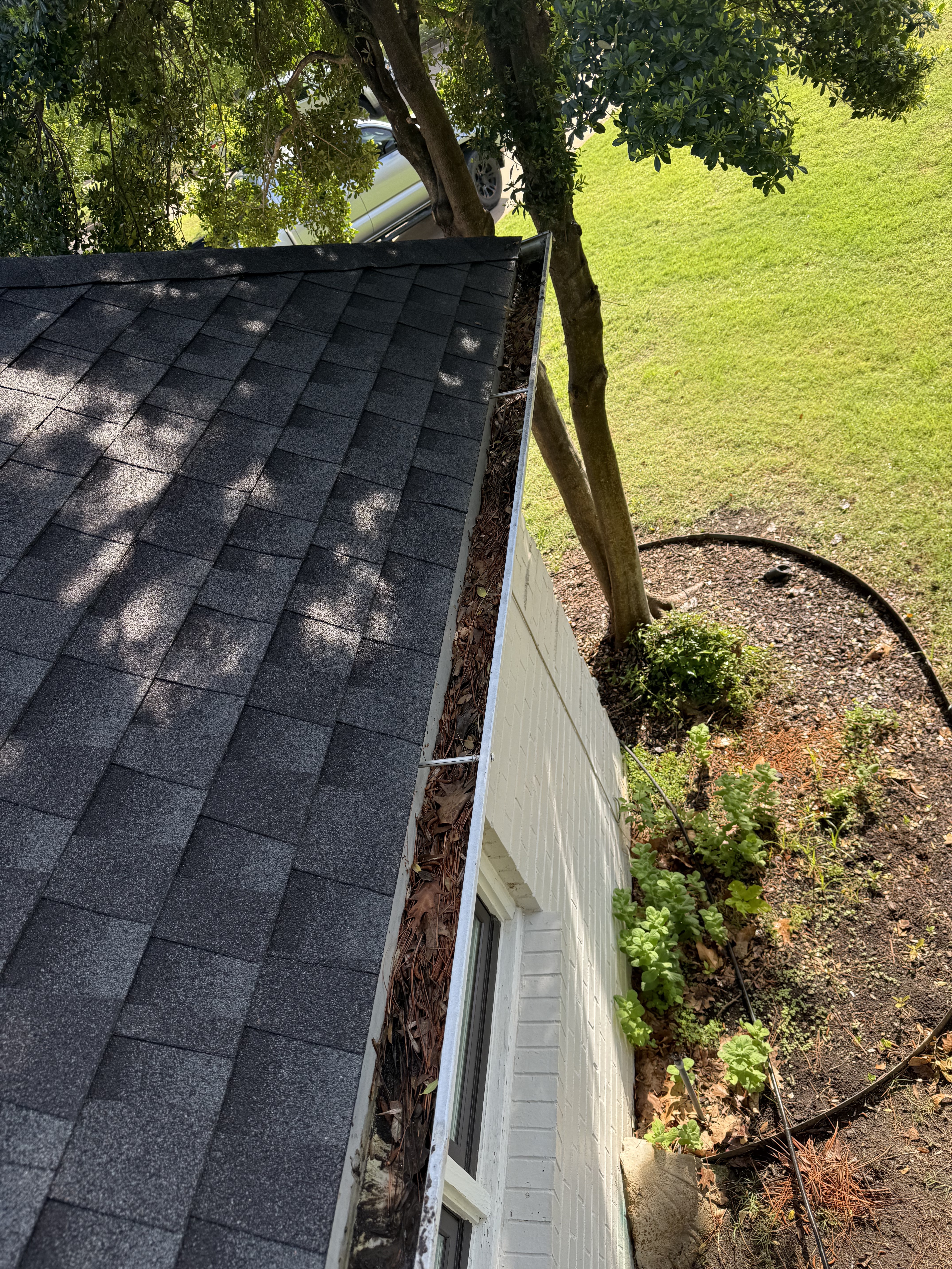 Clogged gutter packed with leaves and debris before cleaning