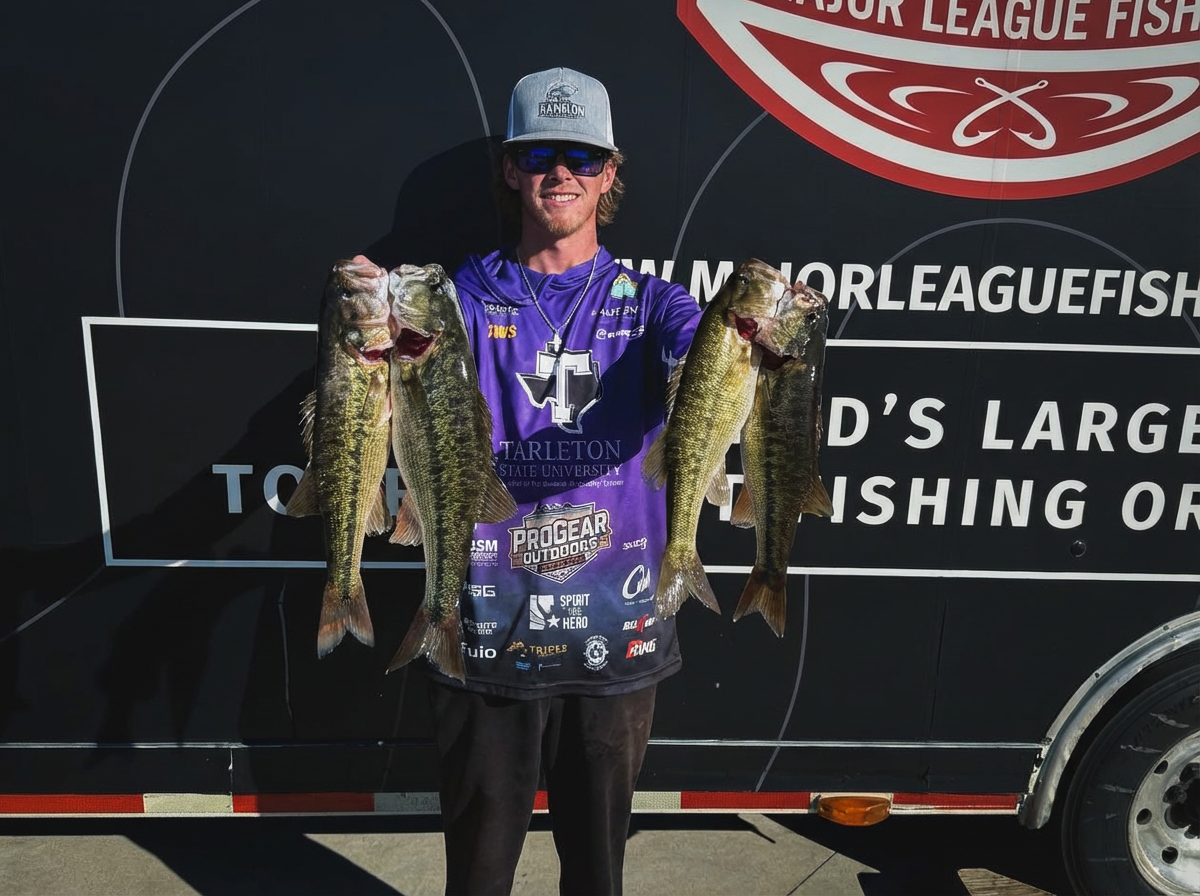 Aiden holding four bass in front of MLF trailer