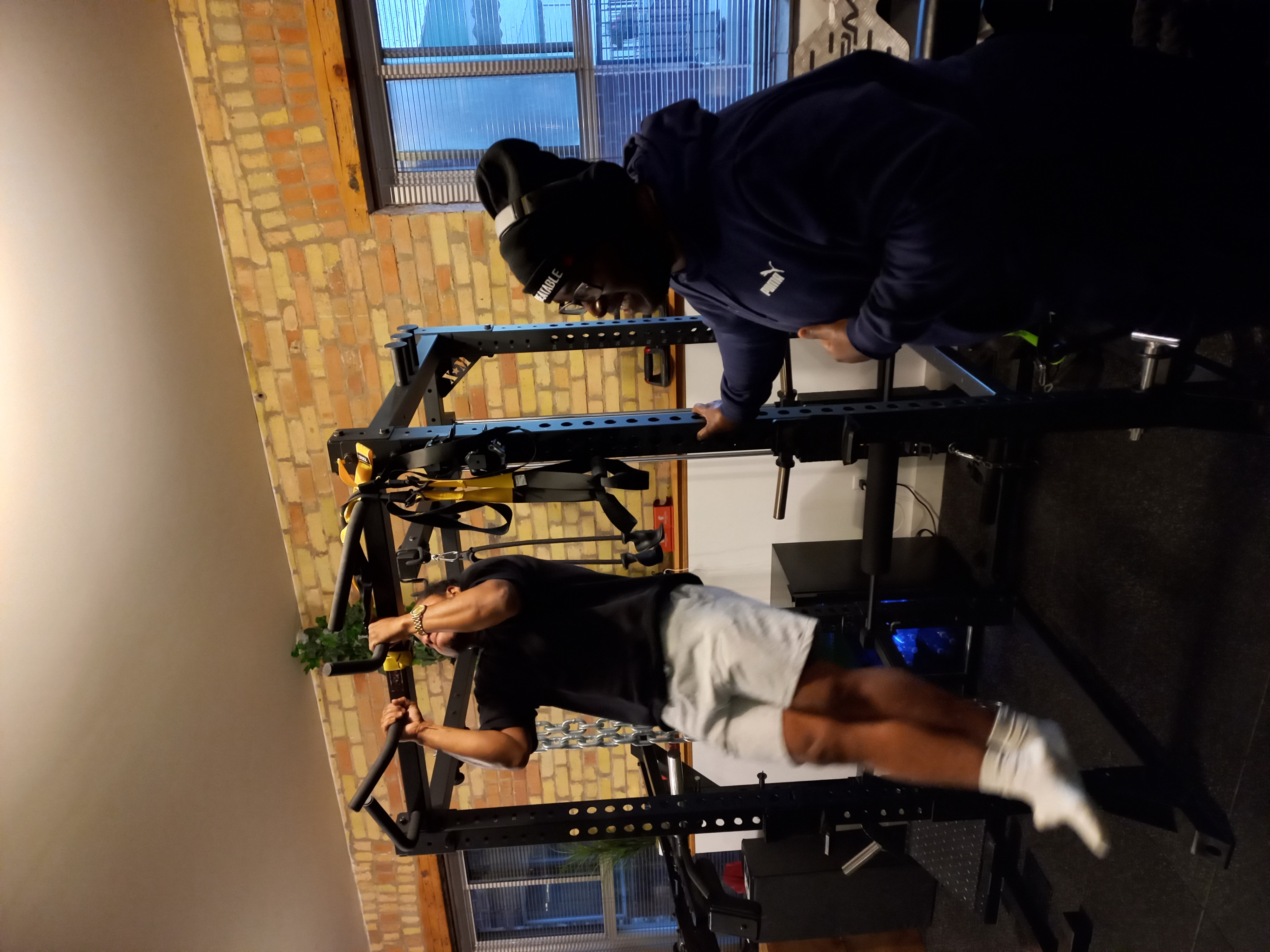 Personal training session at ASquared Fitness - coach supporting client during pull-ups