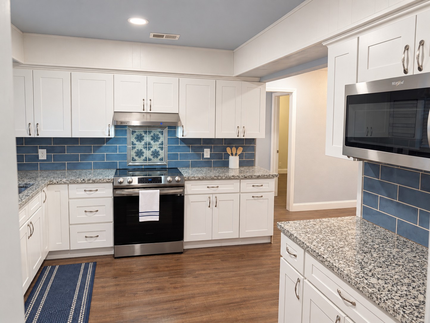 Updated kitchen with stainless Whirlpool appliances and blue subway tile