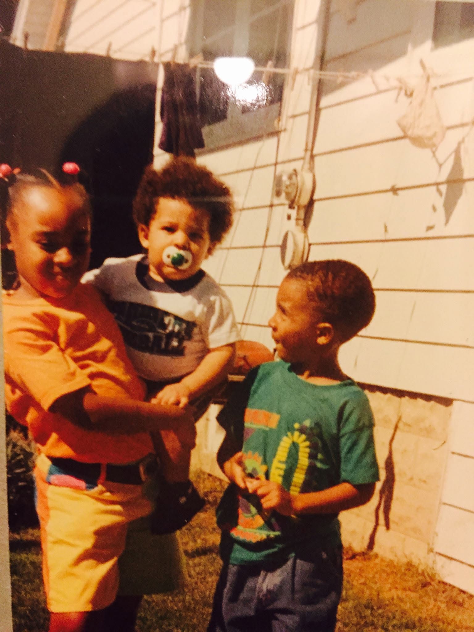 Javon cousins Erica and Mario with baby Javon in a precious family moment from the early years