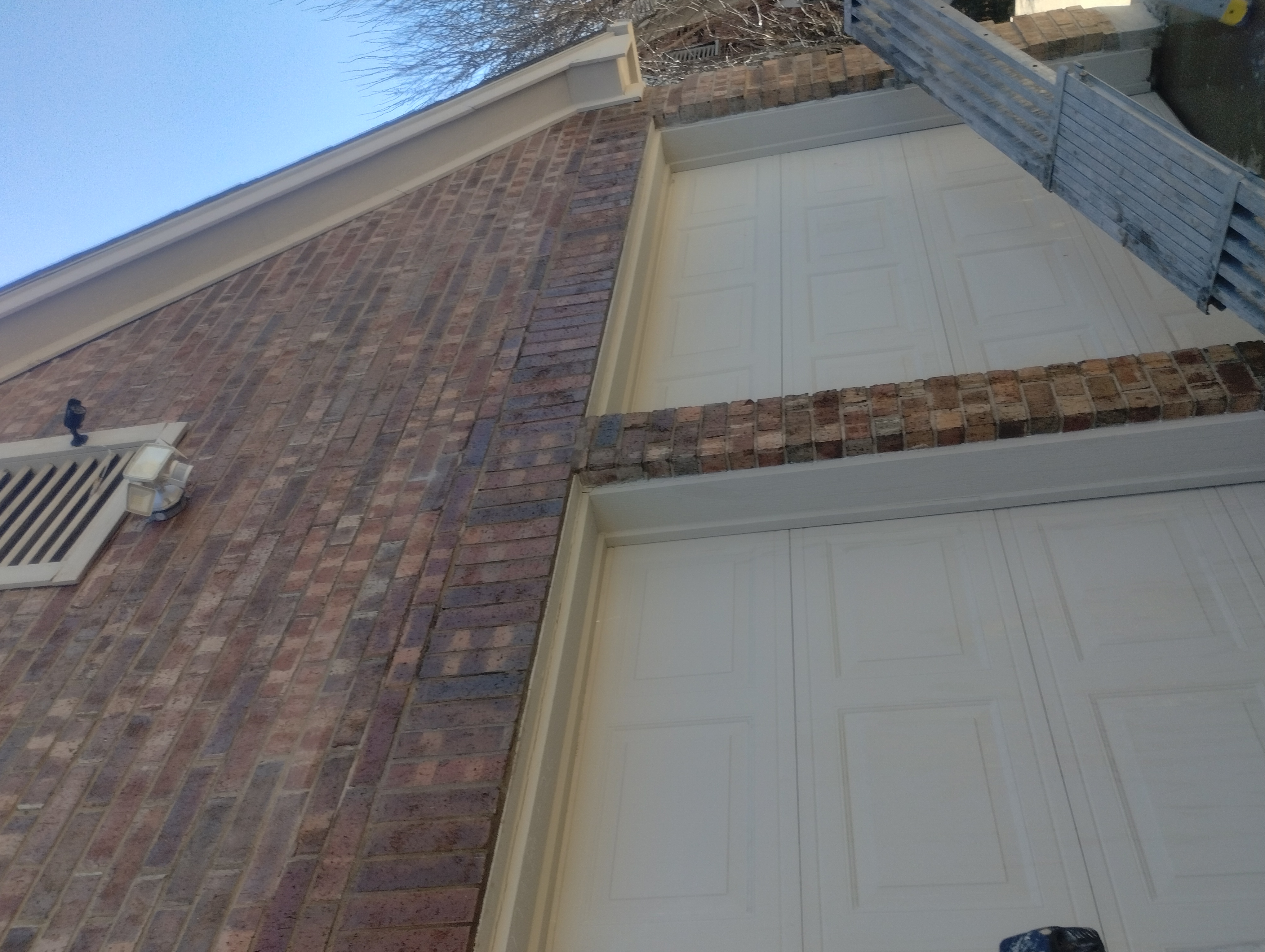 After: Completed LintelLOCK repair — brick restored above dual garage doors