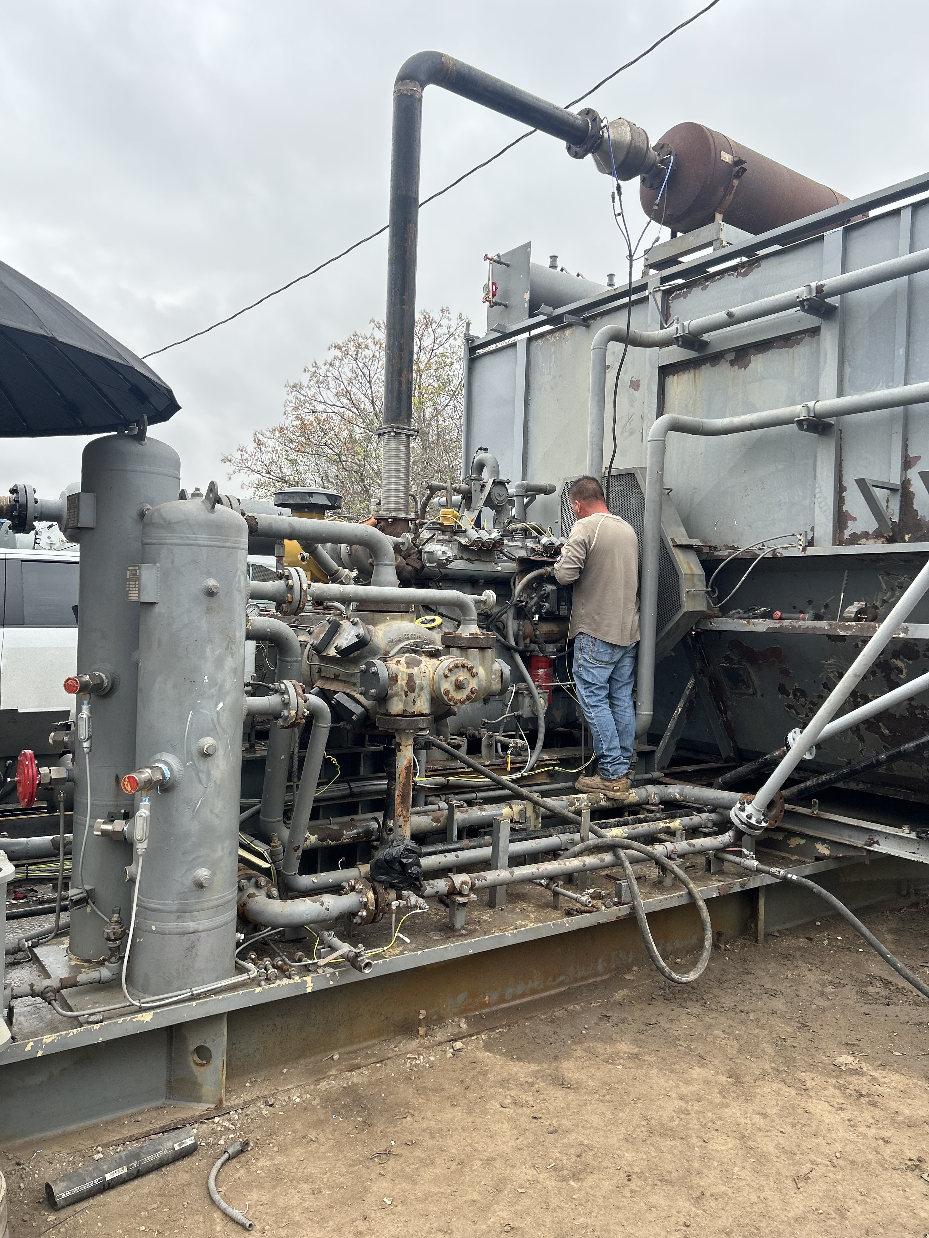Gas lift compressor skid with technician performing final checks