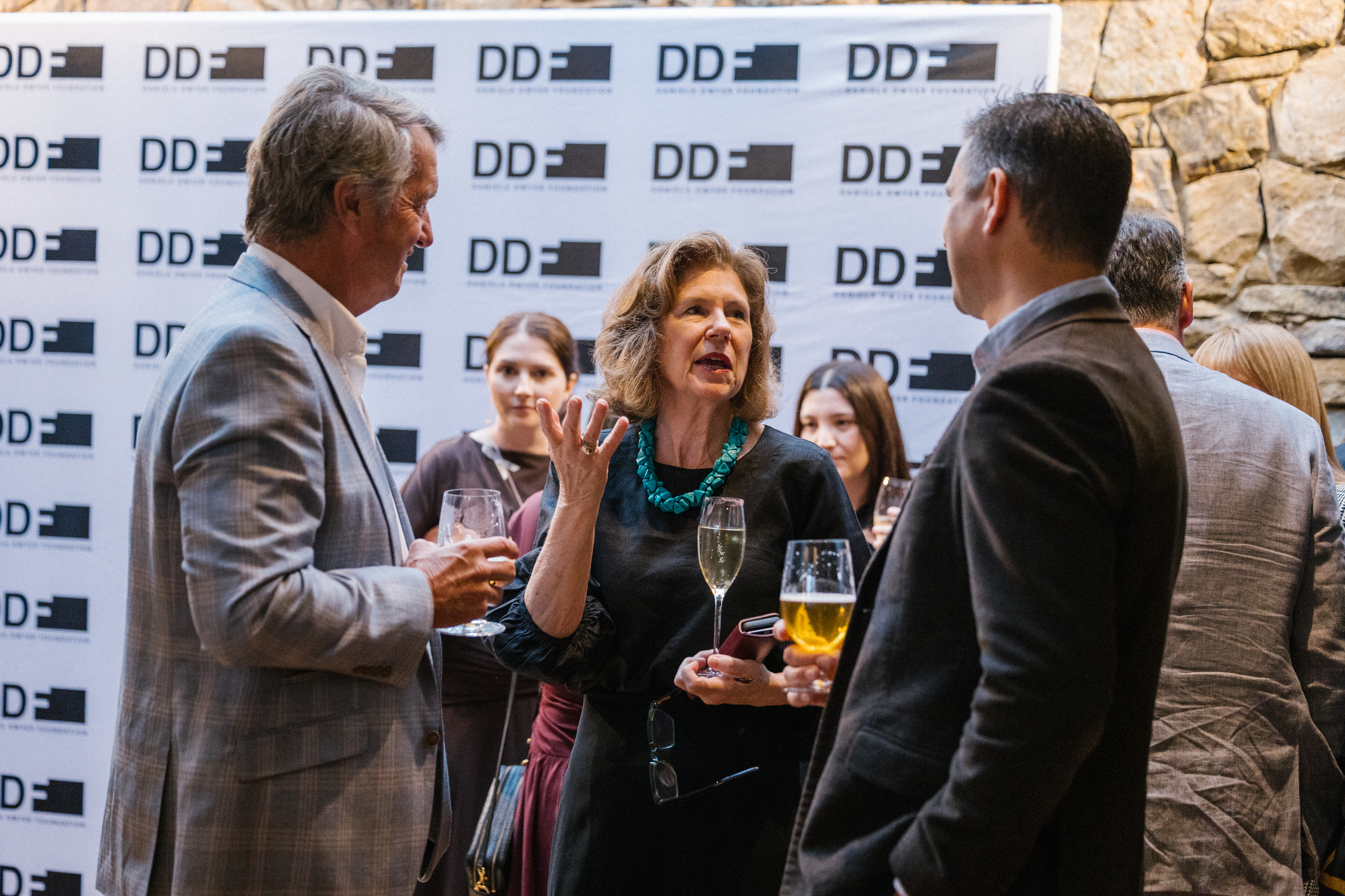 Guests networking at the Dinner for Change with DDF media wall