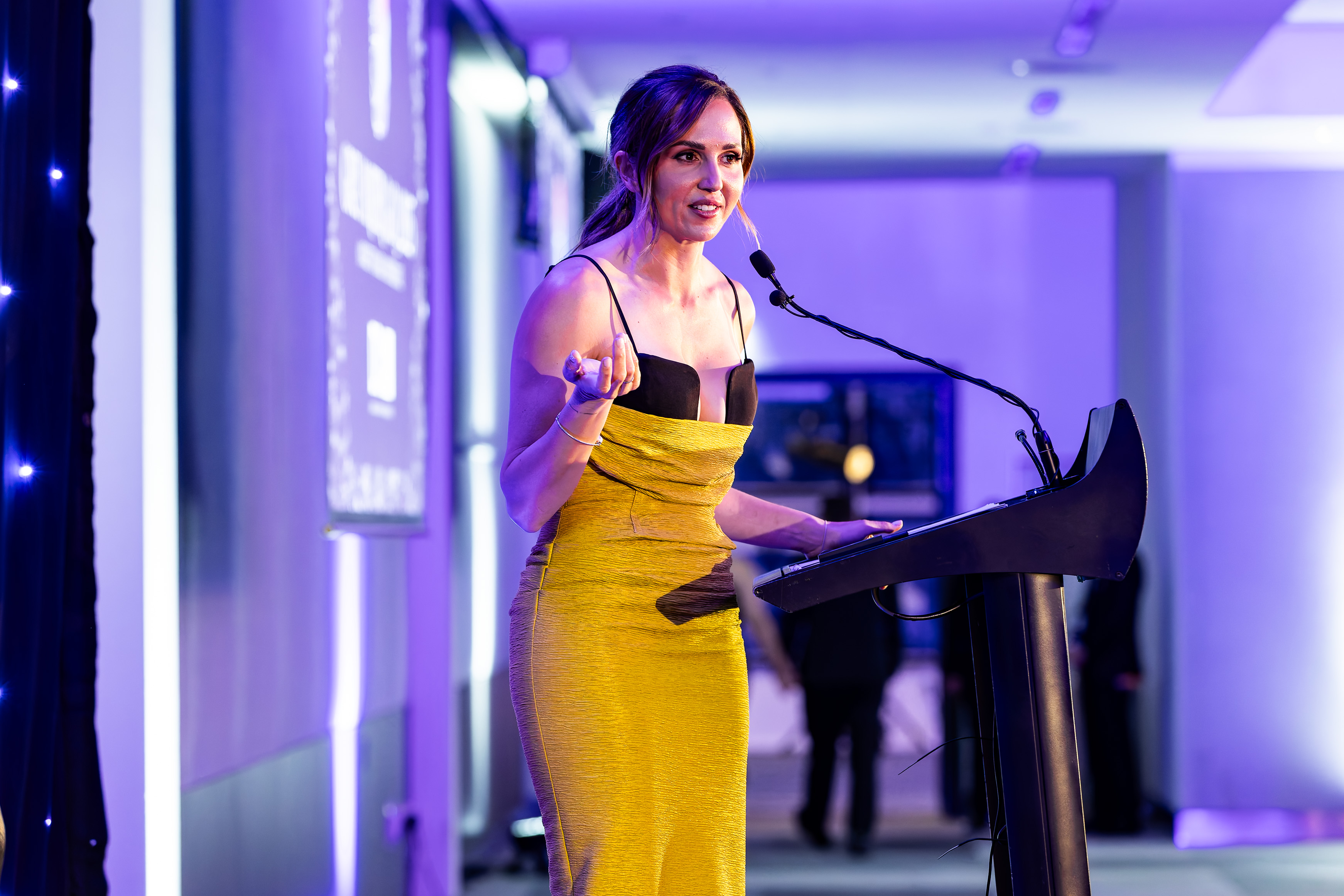 Speaker presenting at the podium at the Grey Matter Gala 2025