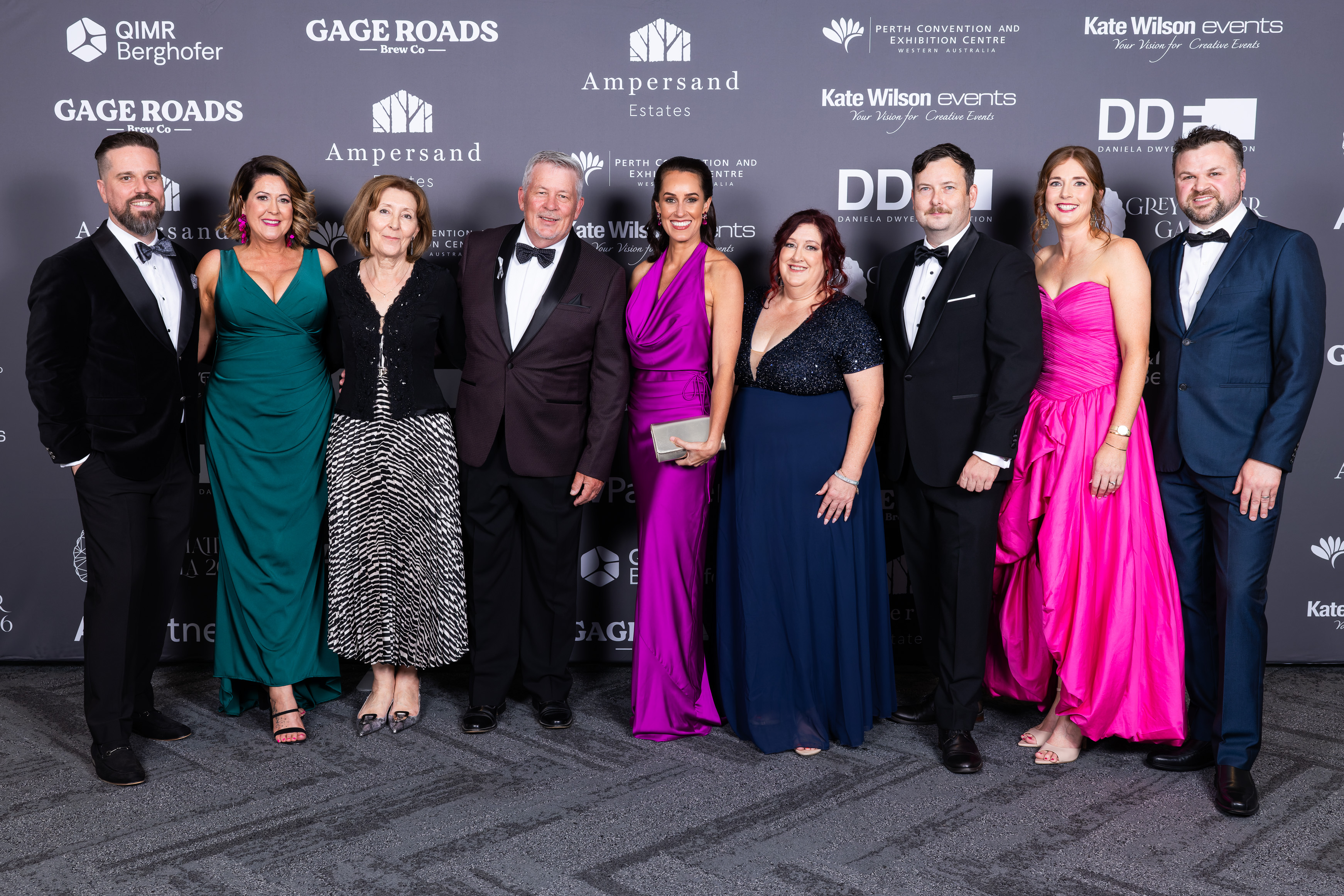 Guests posing in front of the Grey Matter Gala 2026 sponsor media wall featuring QIMR Berghofer, Gage Roads, Ampersand Estates, Kate Wilson Events and DDF