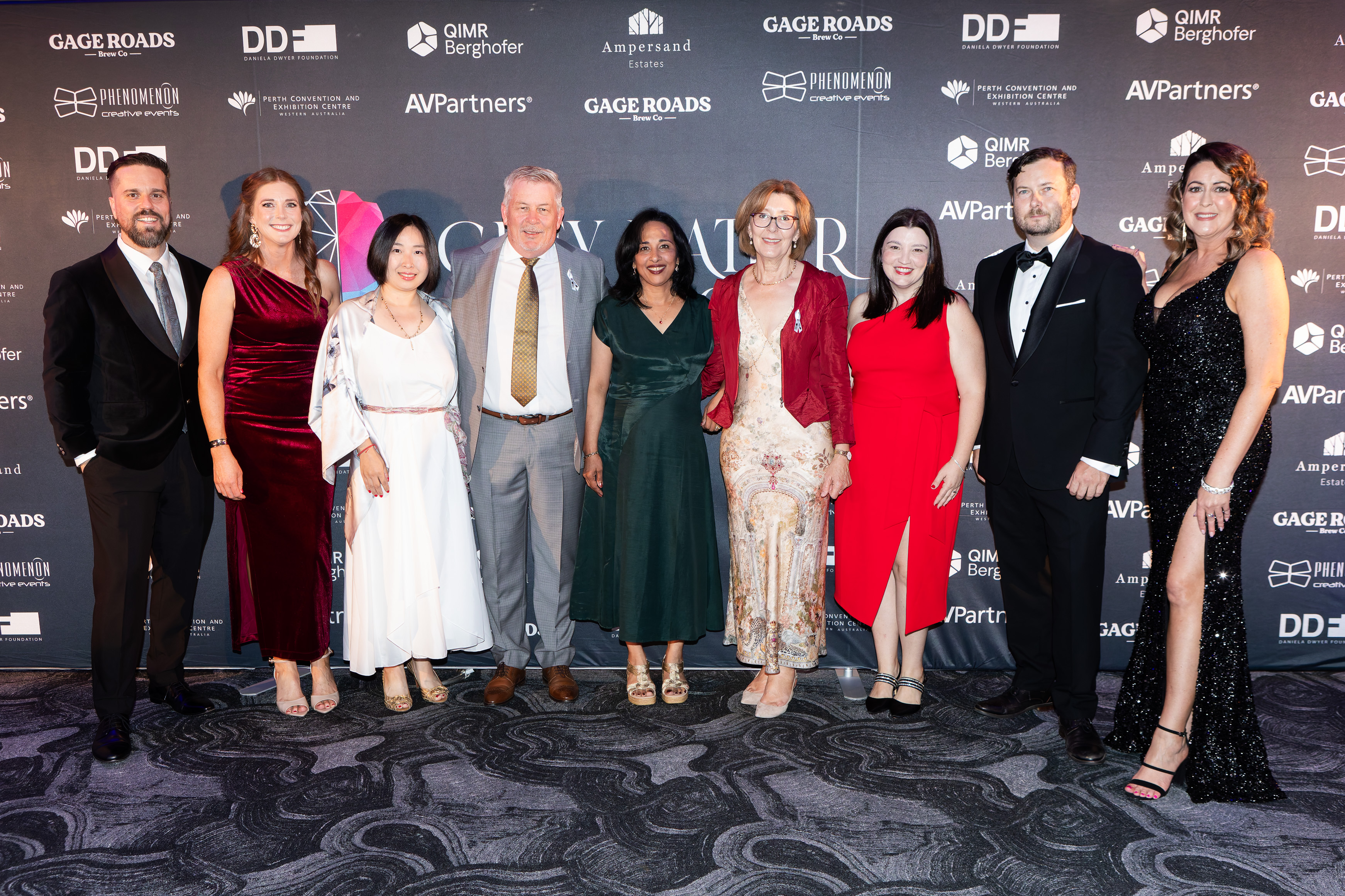 Guests posing in front of the sponsor wall at the Grey Matter Gala 2025