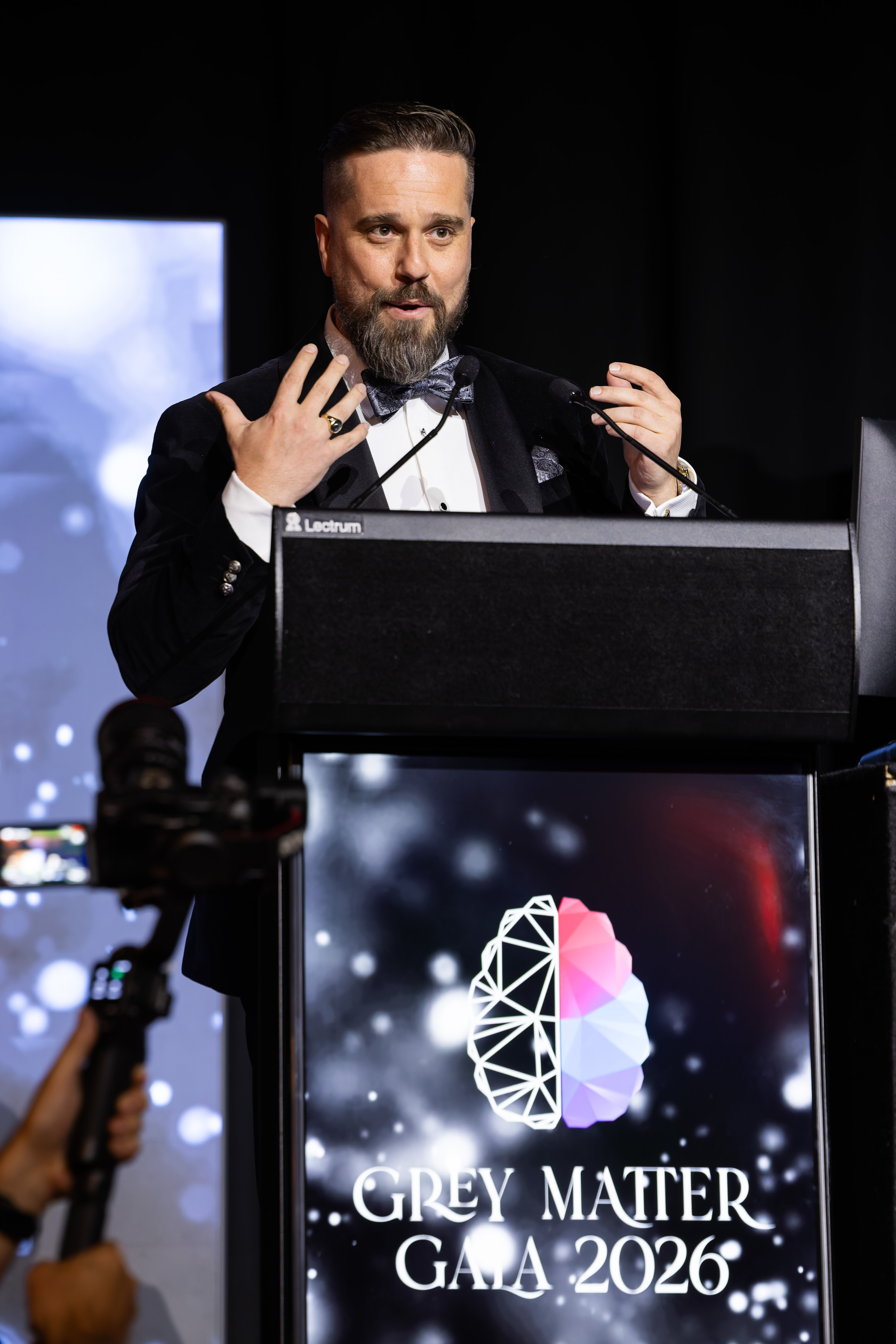 DDF Director Taylor Bow addressing guests from the podium at the Grey Matter Gala 2026