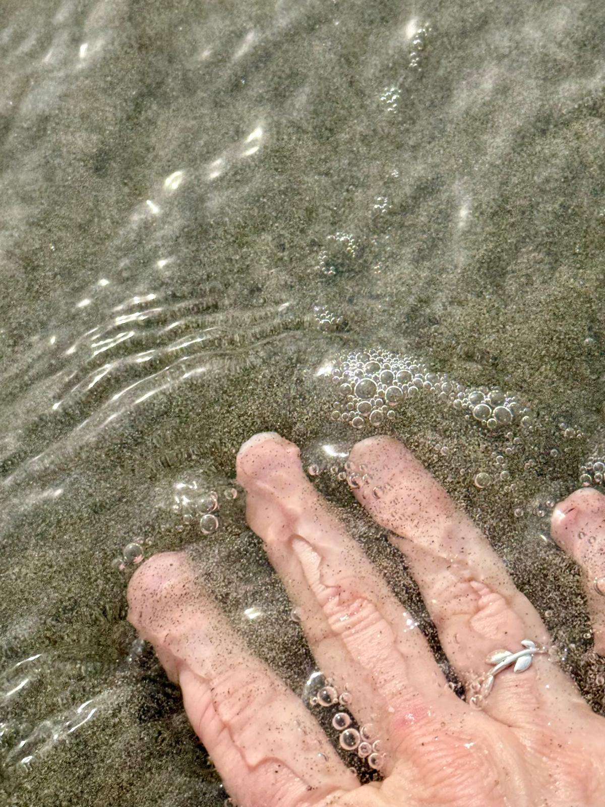 Hand touching the clear waters of the Adriatic coast near Vlorë