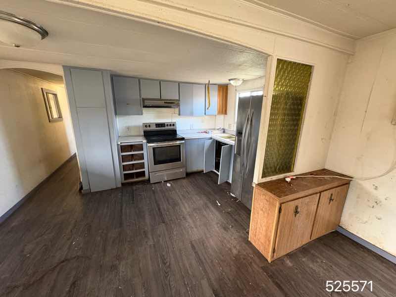 Living area and kitchen — stainless appliances, vinyl plank floors