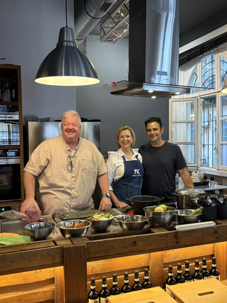 Michael Olson, Anna Olson, and Giovanni in a professional kitchen preparing for a culinary experience