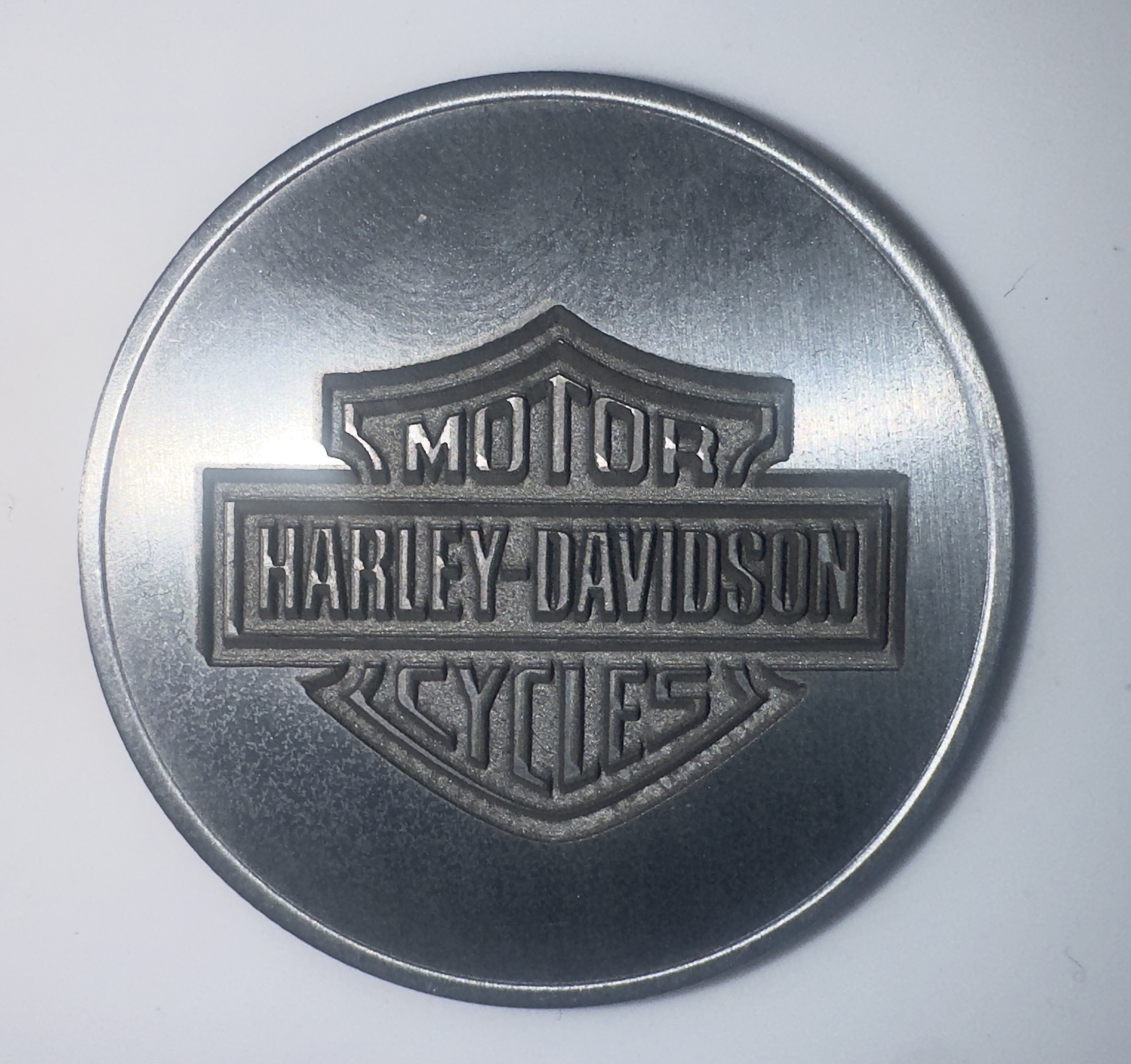 Laser-engraved metal round featuring a Harley-Davidson Motor Cycles logo