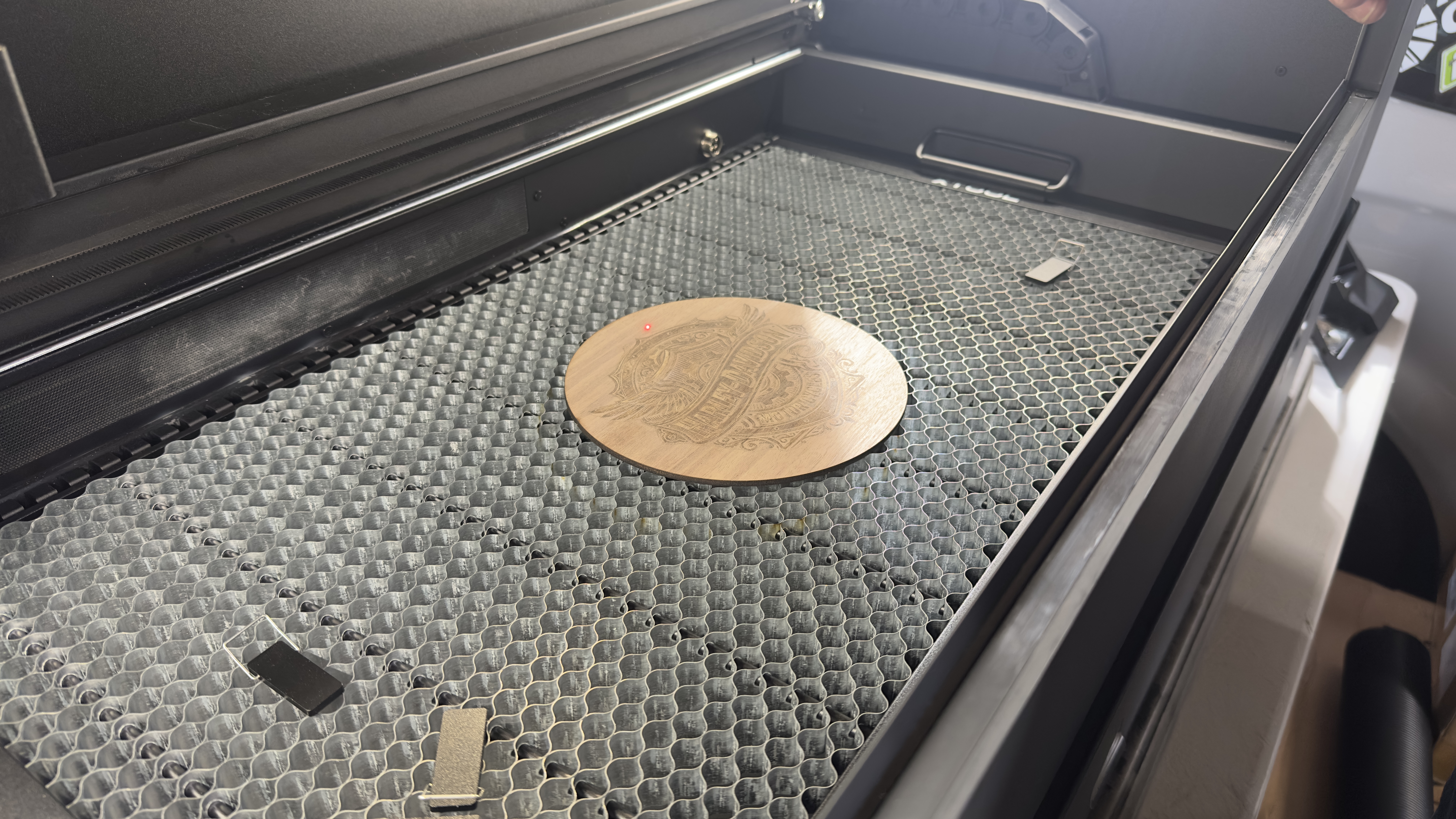 Engraved wood round inside the laser cutter bed