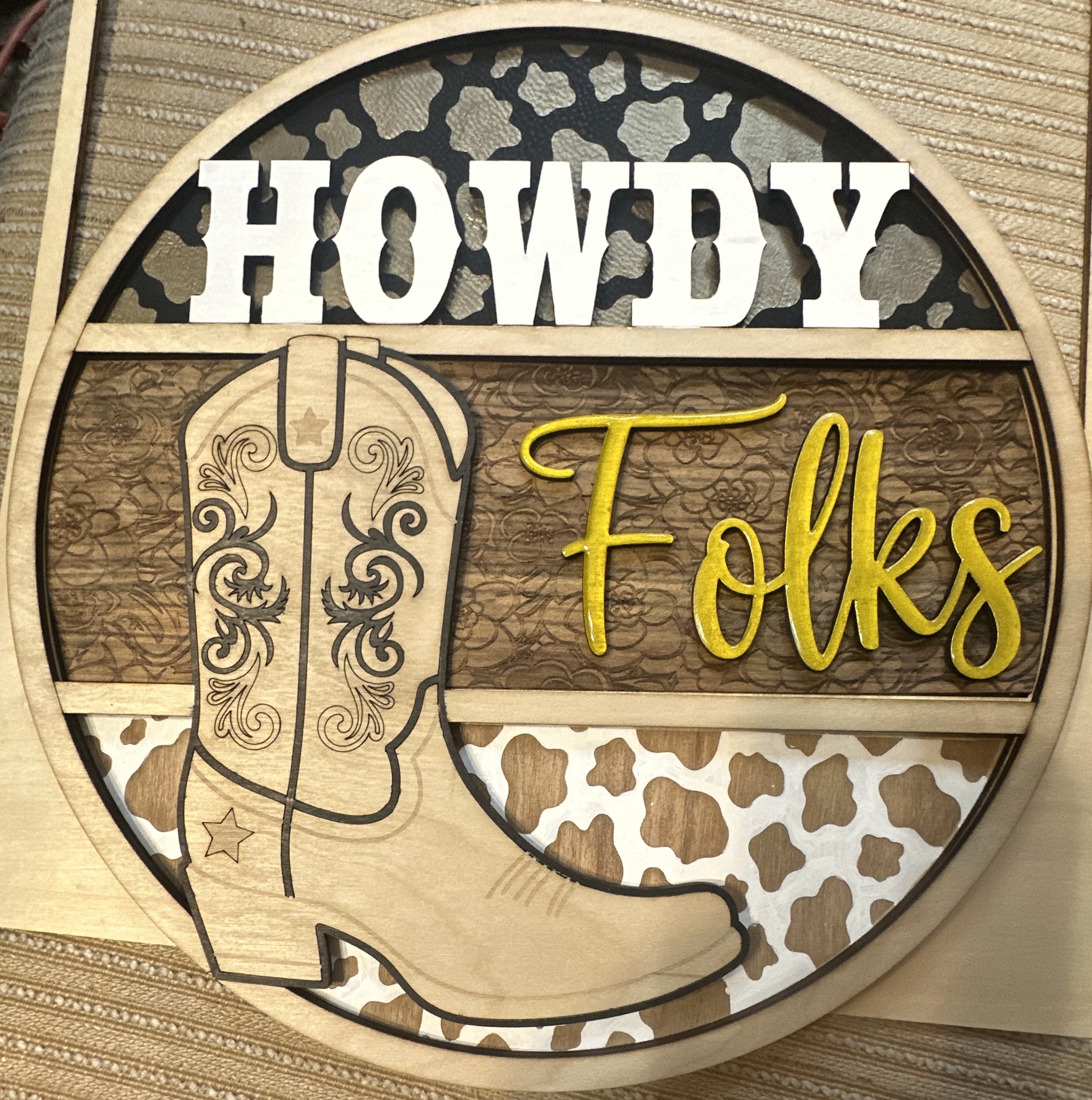 Layered wood sign reading 'Howdy Folks' with cowboy boot silhouette and mixed textures