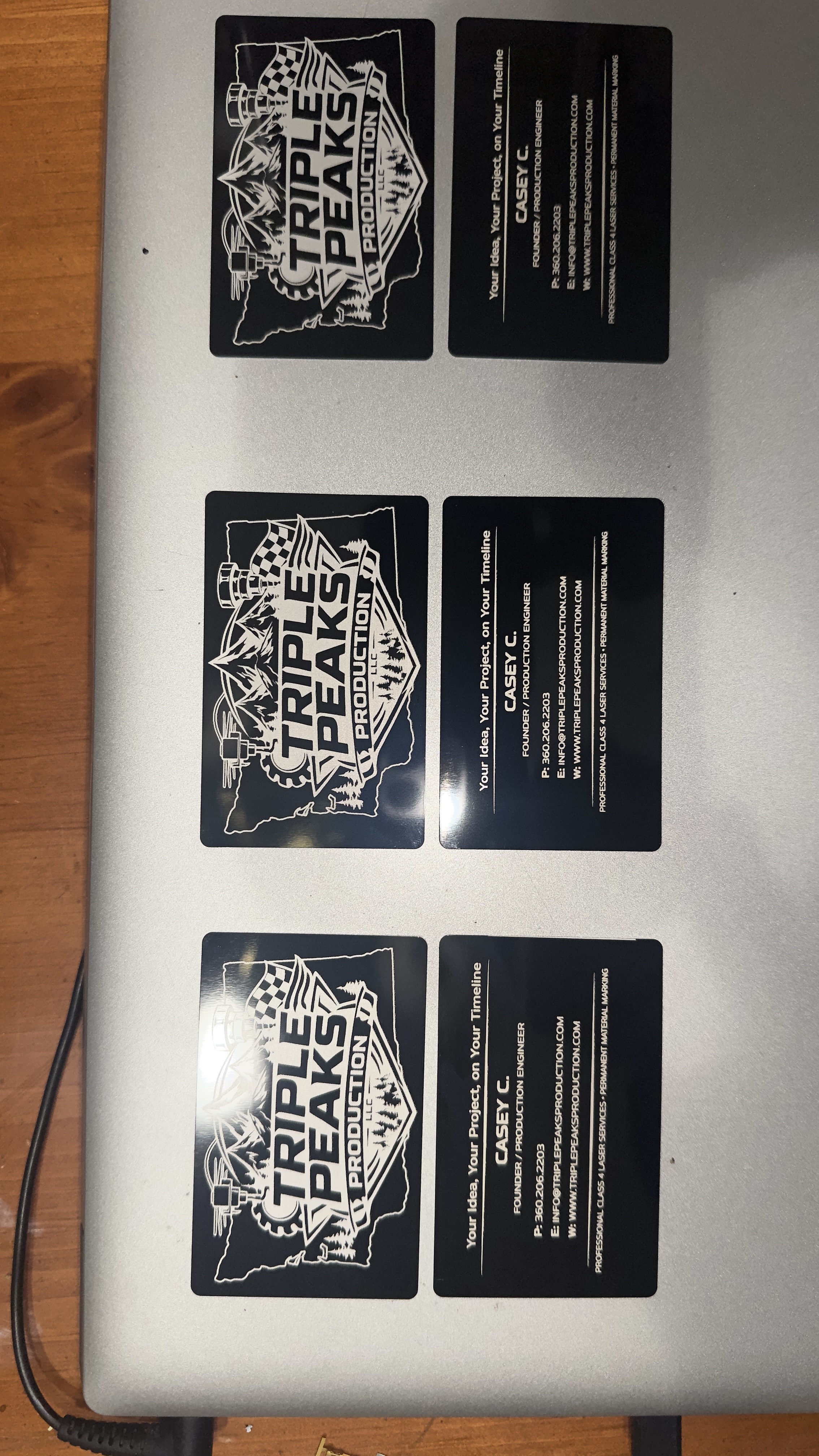 Multiple sets of Triple Peaks Production metal business cards